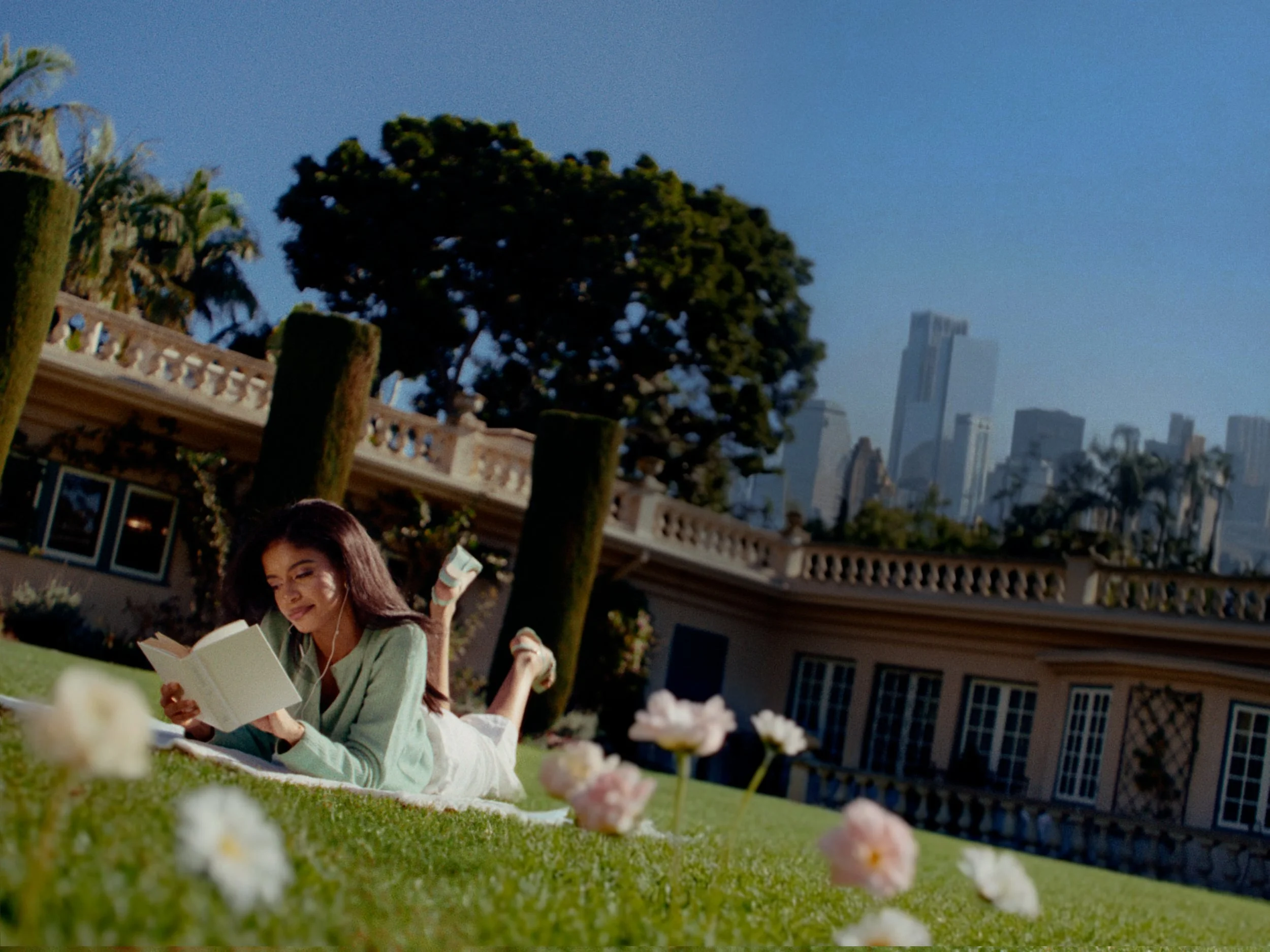 pashion convertible high heels a woman laying down on the grass in a park reading