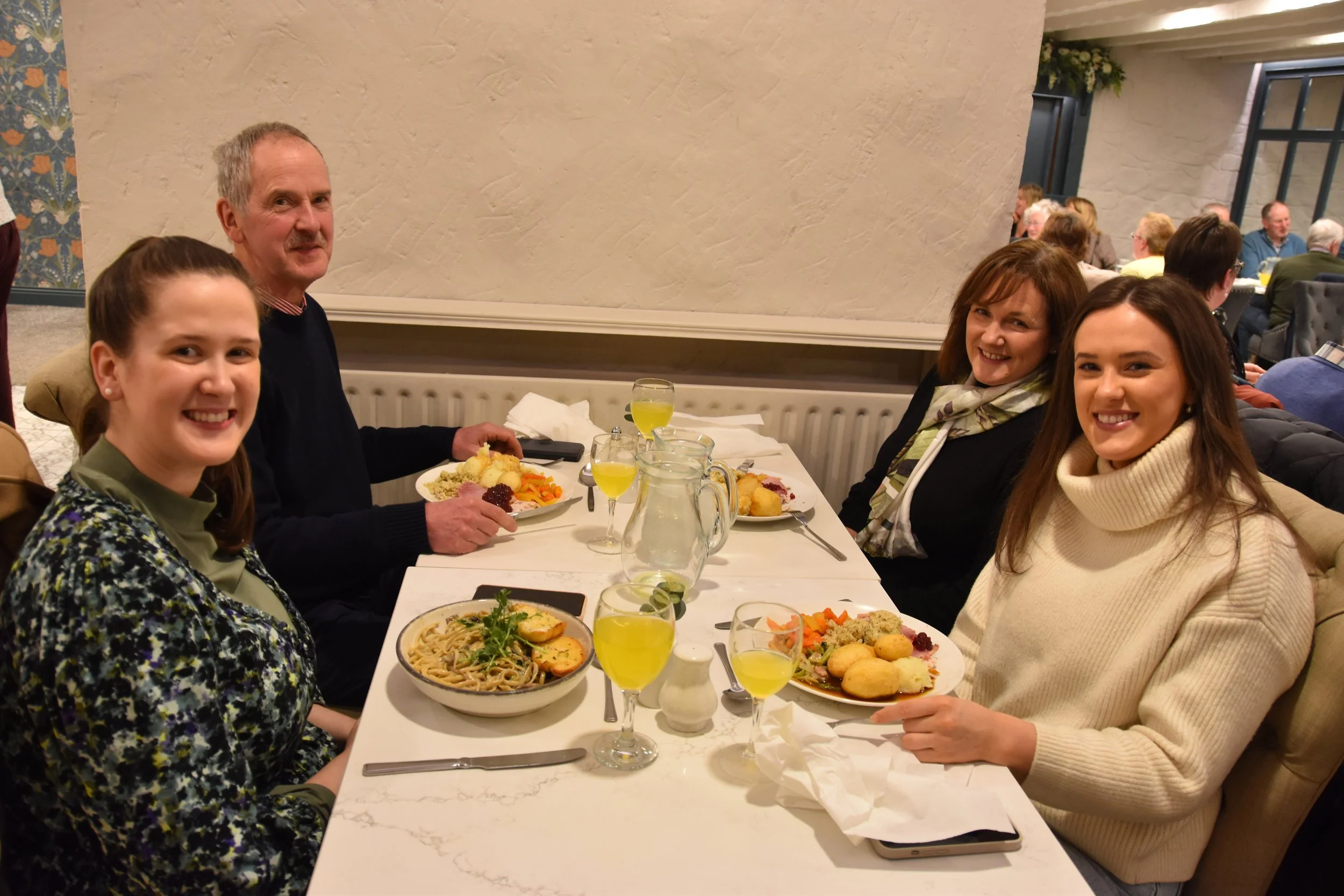 Church members smiling across the table at a shared meal