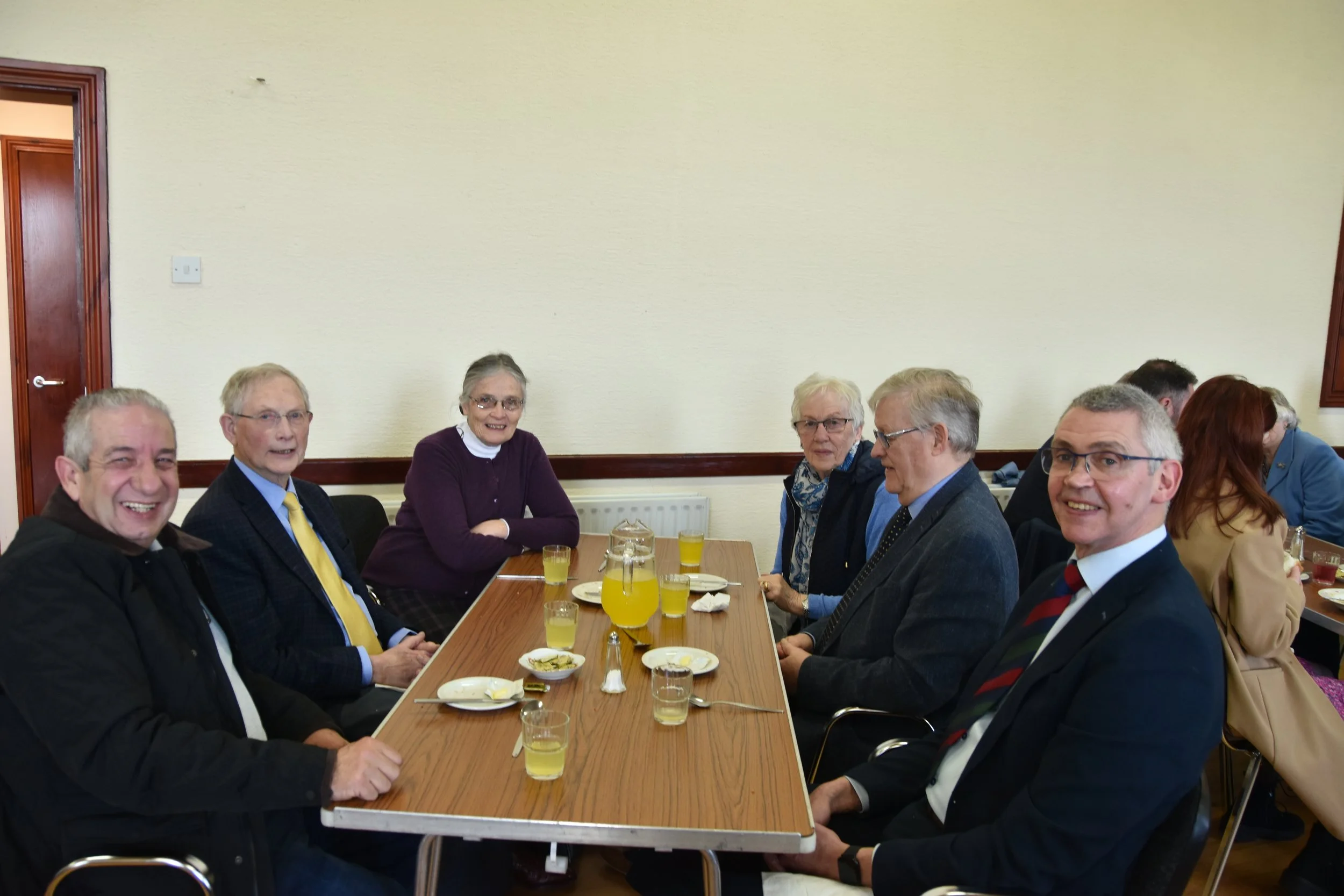 Men from the congregation sharing a meal around a table