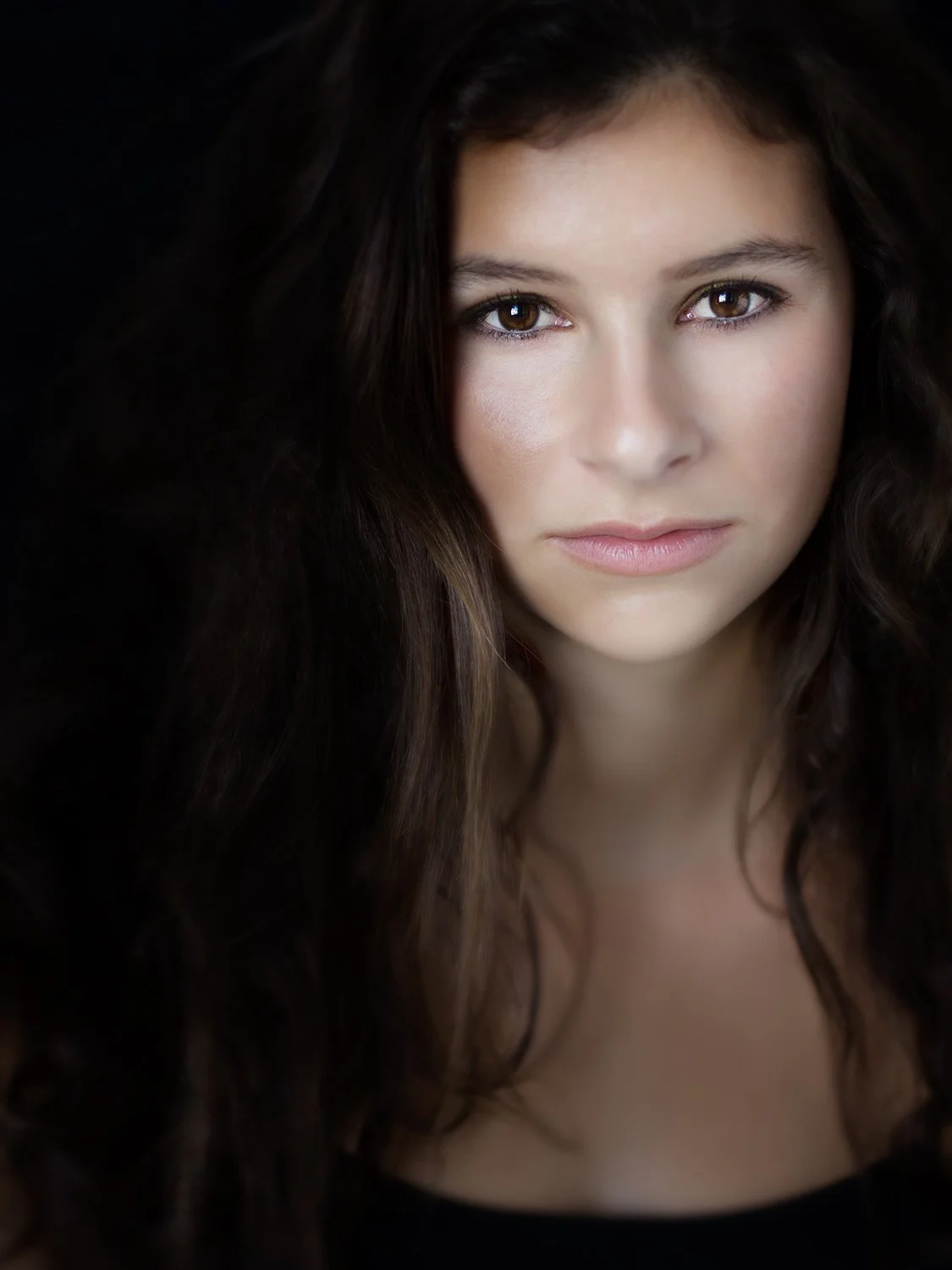Editorial portrait of a young woman with dramatic lighting by Vera Gošić Photography
