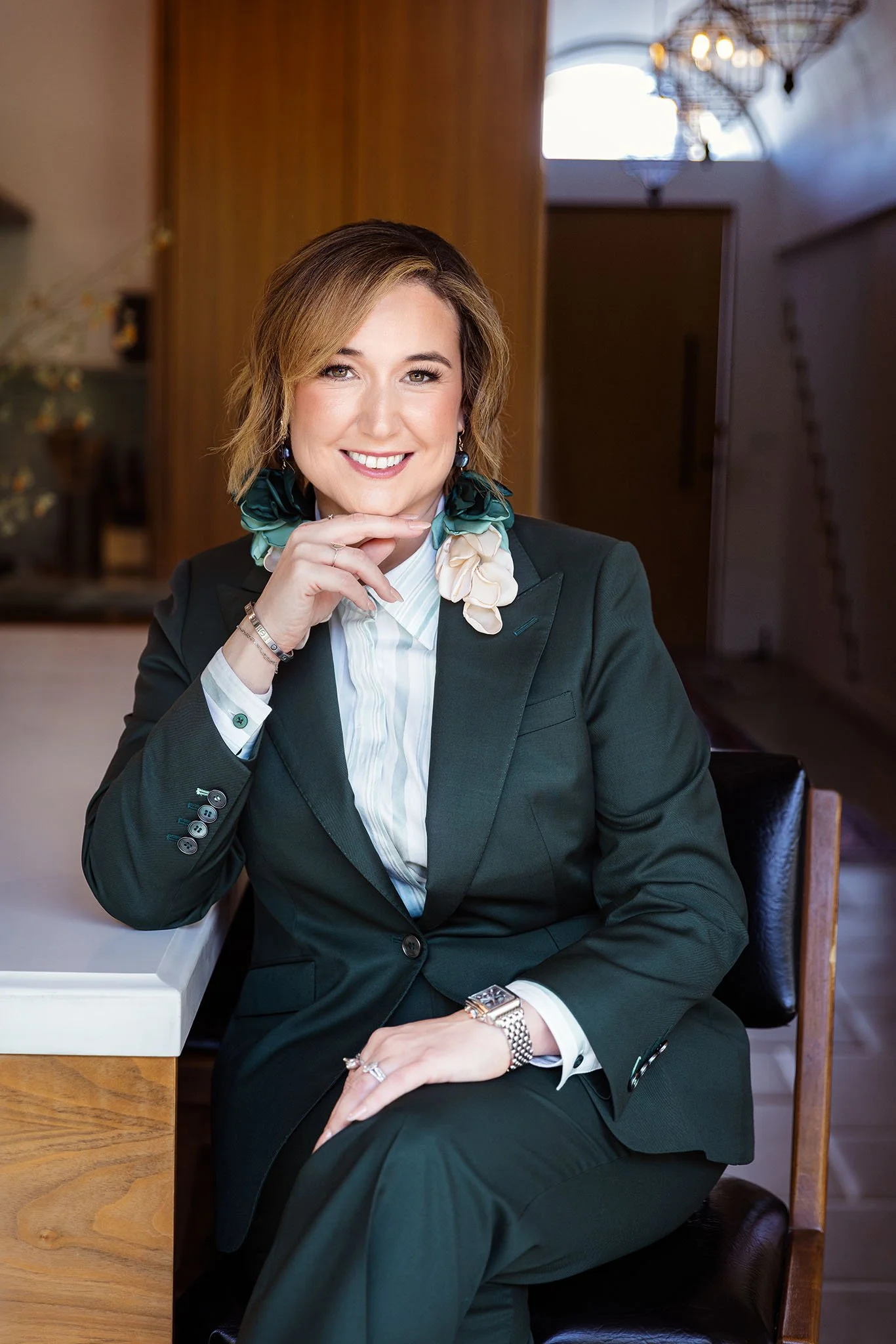 Heather Chee, Orange County personal stylist and founder of Stylized Threads, seated in a green suit with floral accessories, confident founder portrait — branding photography by Vera Gosic, Long Beach