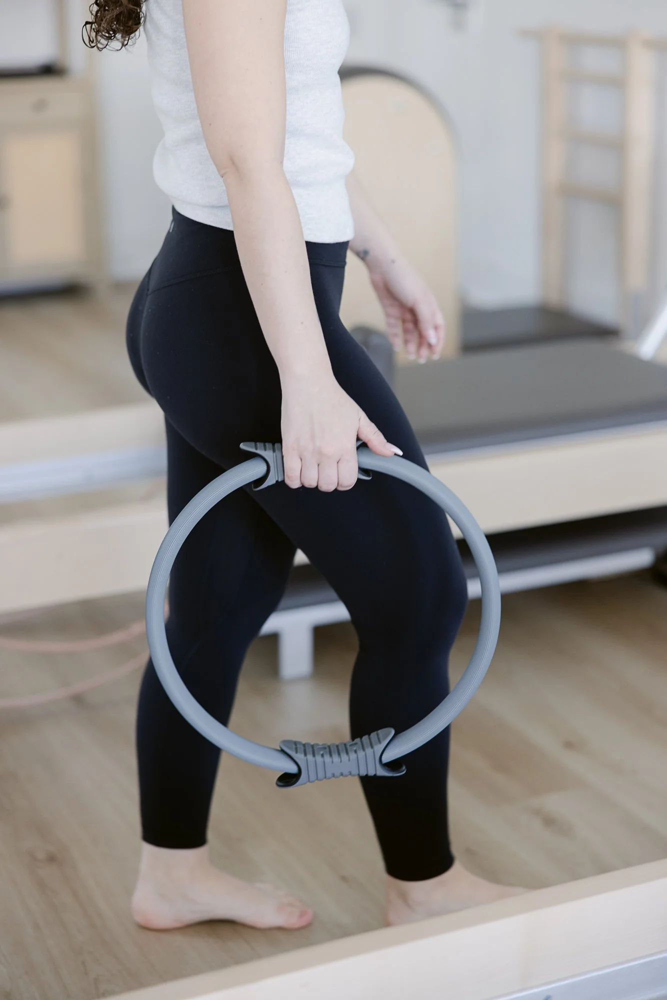 Person holding a Pilates ring in a fitness studio.