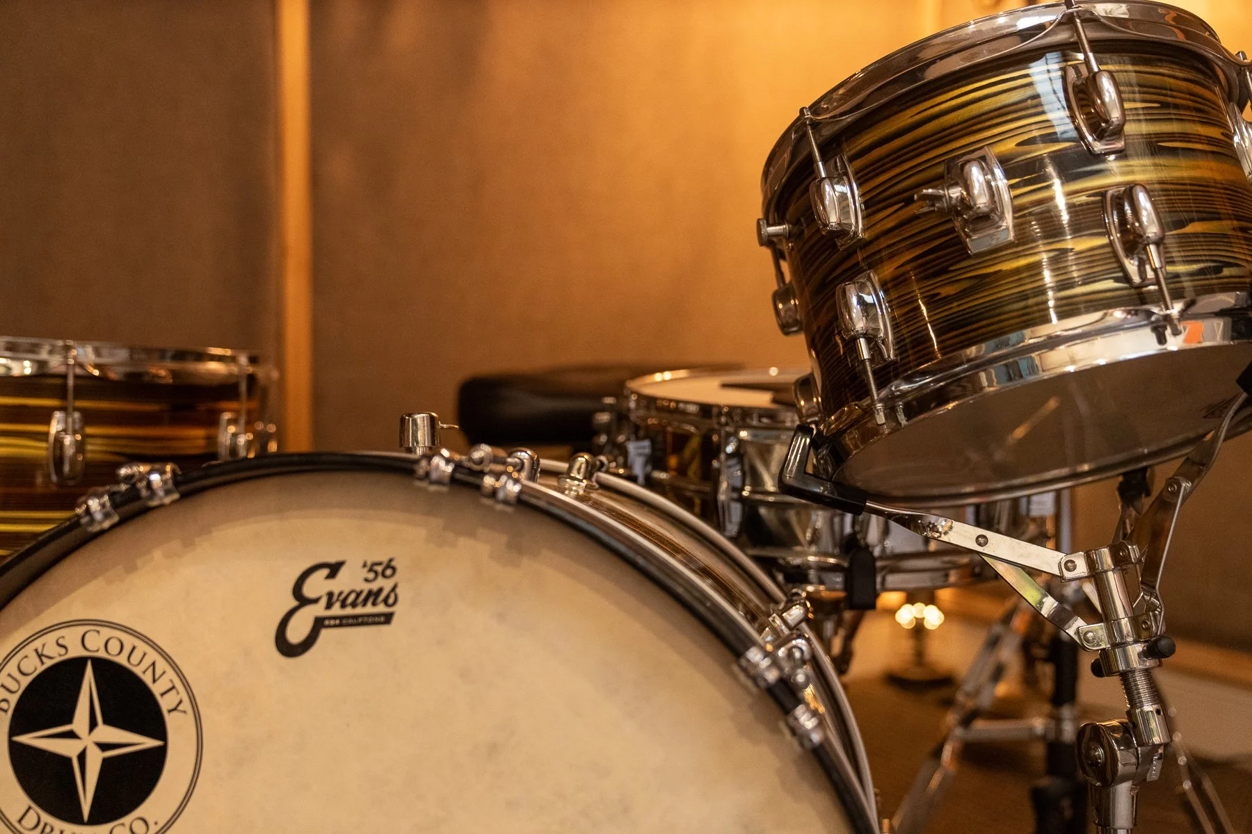 A drum set with a bass drum, a tom-tom, and a snare drum in a music studio