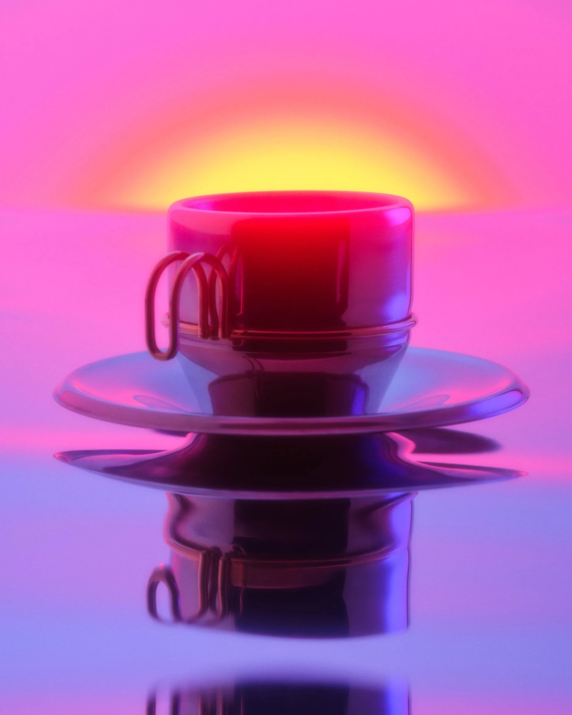 Still life photo of a chrome cup and saucer. The cup is engulfed in neon purple light and a bright yellow light glows over the lip.