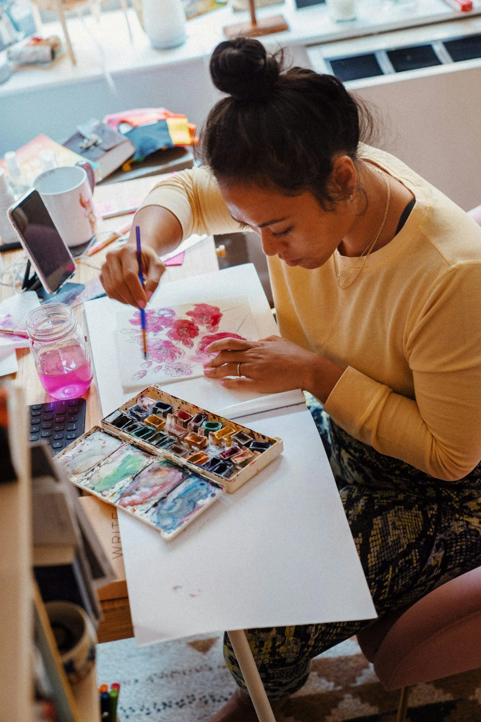 Woman painting with watercolors during an art therapy session, expressing emotions through creative process.