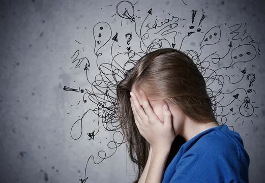 Woman with head in hands surrounded by chaotic doodles, symbolizing stress, overwhelm, and struggles with ADHD.