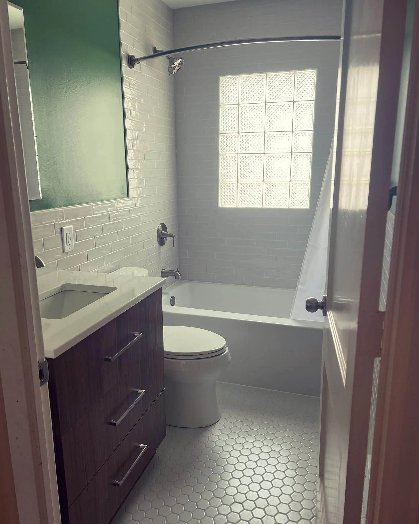 Close-up of a luxury white quartz bathroom countertop with an undermount sink and custom cabinetry in an Urbandale residential renovation.