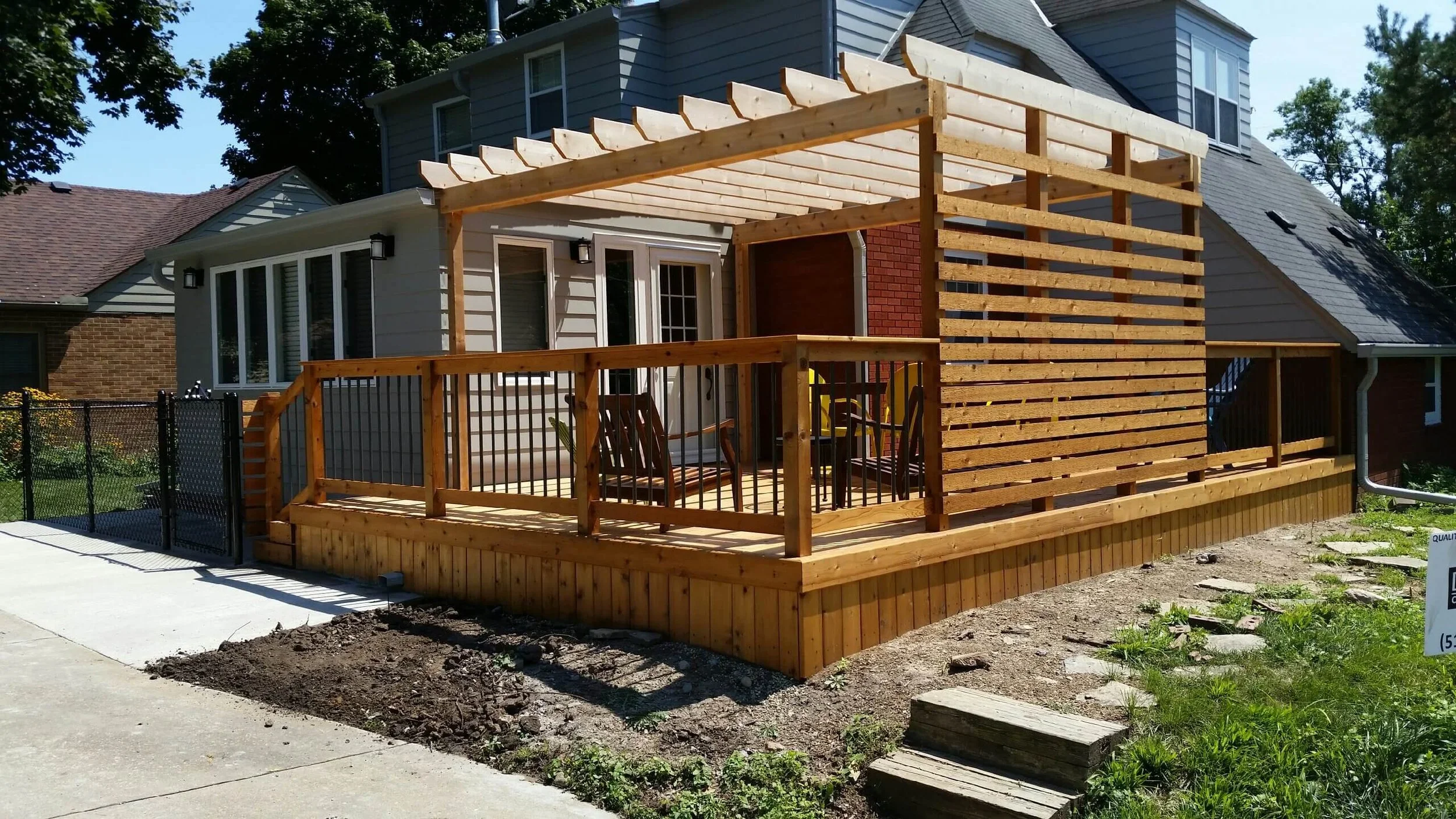 Custom wood deck with pergola and privacy screen built for a backyard in Des Moines Iowa