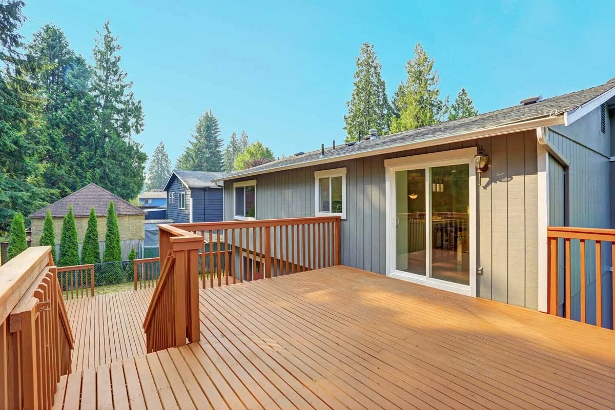 Elevated wood deck in Des Moines attached to a residential home, featuring custom railing and sliding glass door access.