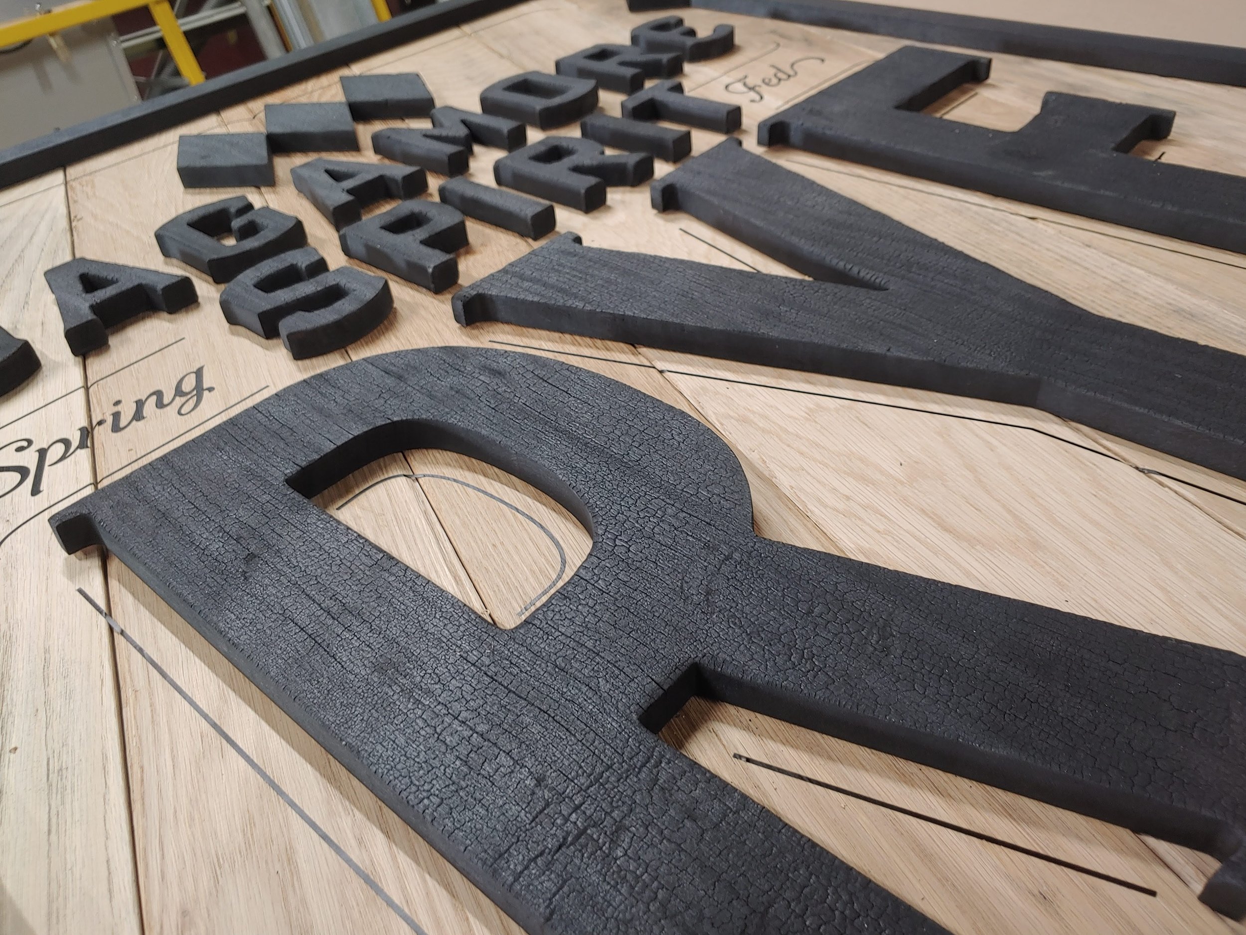Close-up of wooden letters and words on a wooden surface, with the words "Spring" and "Feed" visible.
