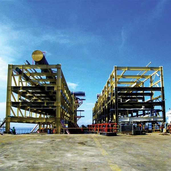 Large offshore oil platform structure under construction against a blue sky.