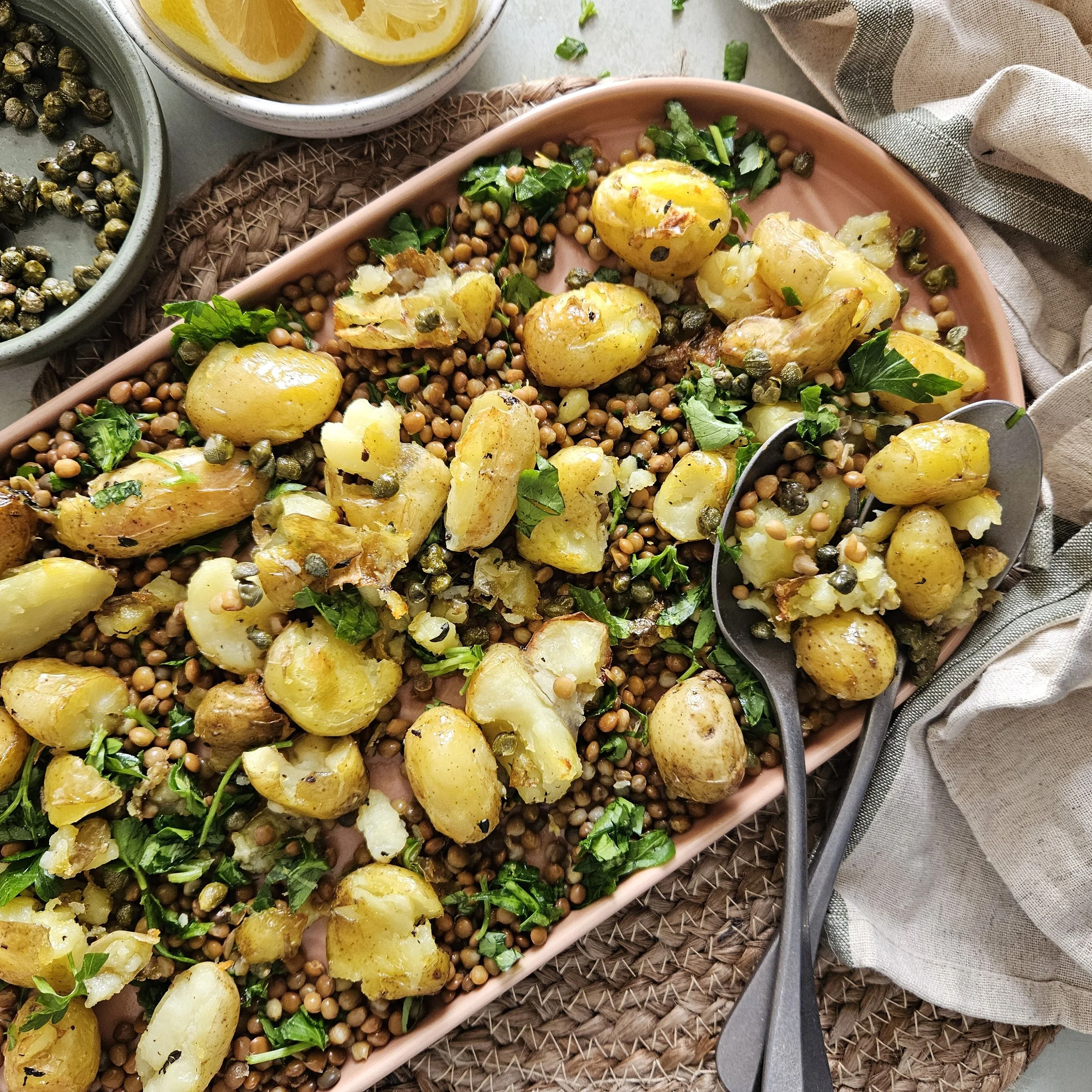 Smashed Jersey Royal potato roasties with lentils, herbs, lemon and crispy capers 