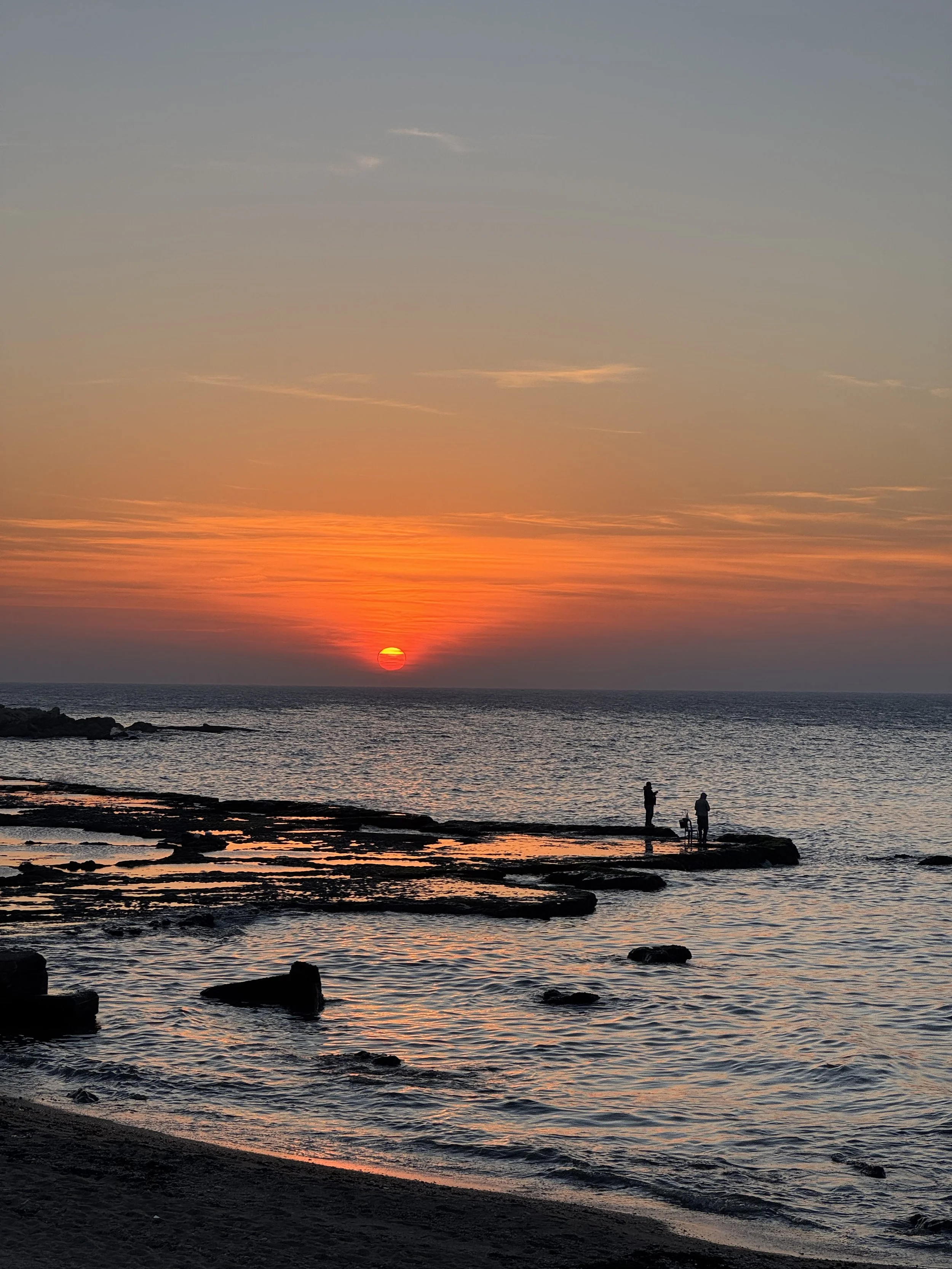 Coucher de soleil couleur orangée sur la mer lisse avec la plage au Liban