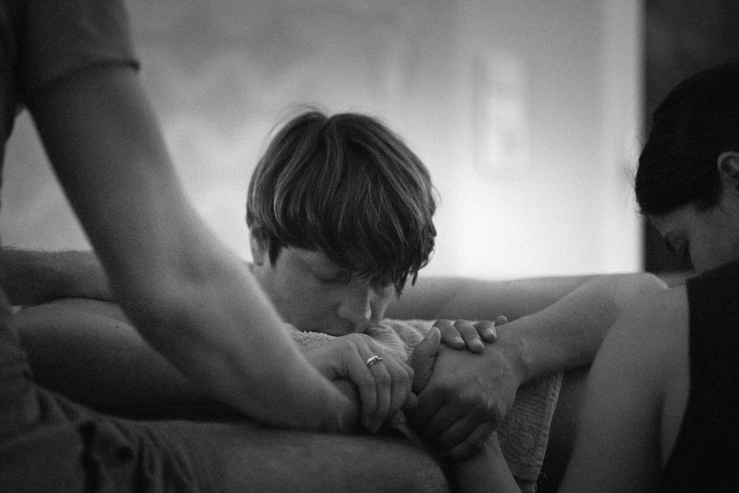 A person receiving a massage with closed eyes, one hand on their shoulder, in a calming indoor setting.