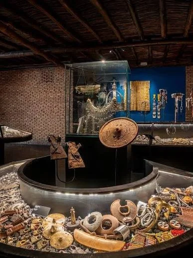 Een antiekmuseum met een schat aan oude voorwerpen, waaronder sieraden, vazen en kunstvoorwerpen, tentoongesteld in een ronde vitrine en achter een glazen kast.
