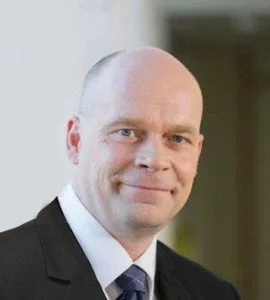 Bald man in suit smiling