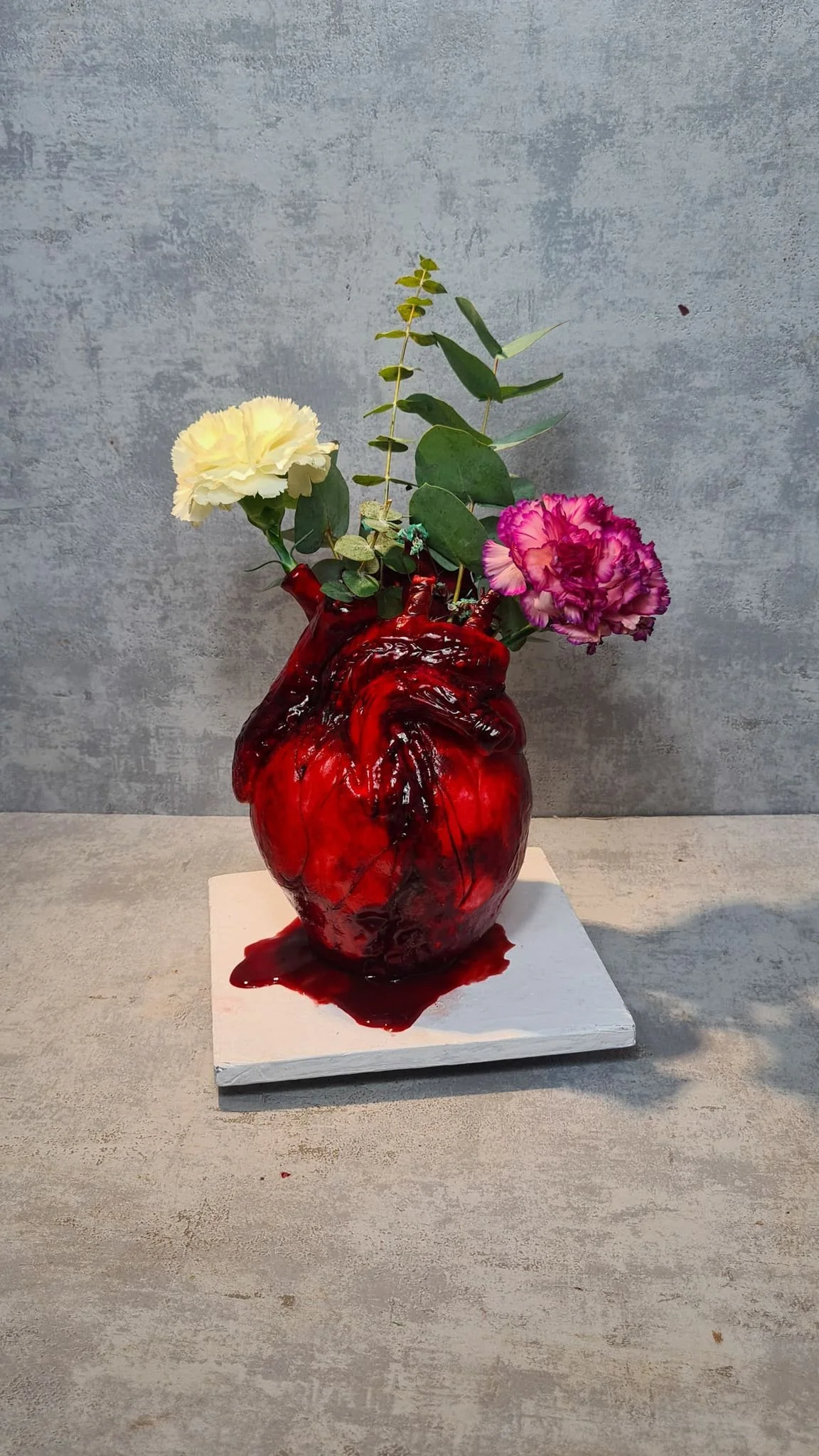 Vase en forme de cœur avec fleurs carnations et feuillage, posé sur une plateforme blanche. Gateaux sur mesure Maison Tchovi , halloween , Cake design bordeaux