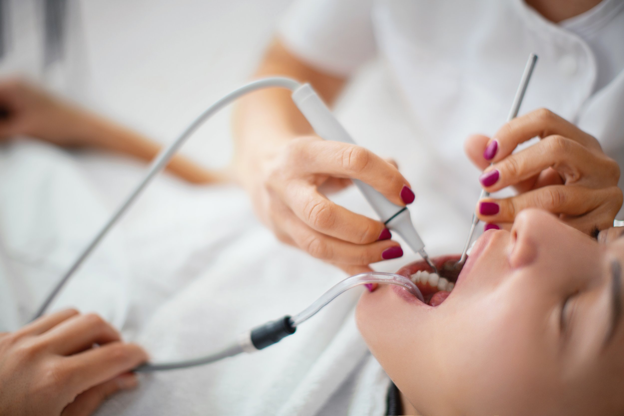 Dentist performing a dental procedure on a patient in a dental chair.