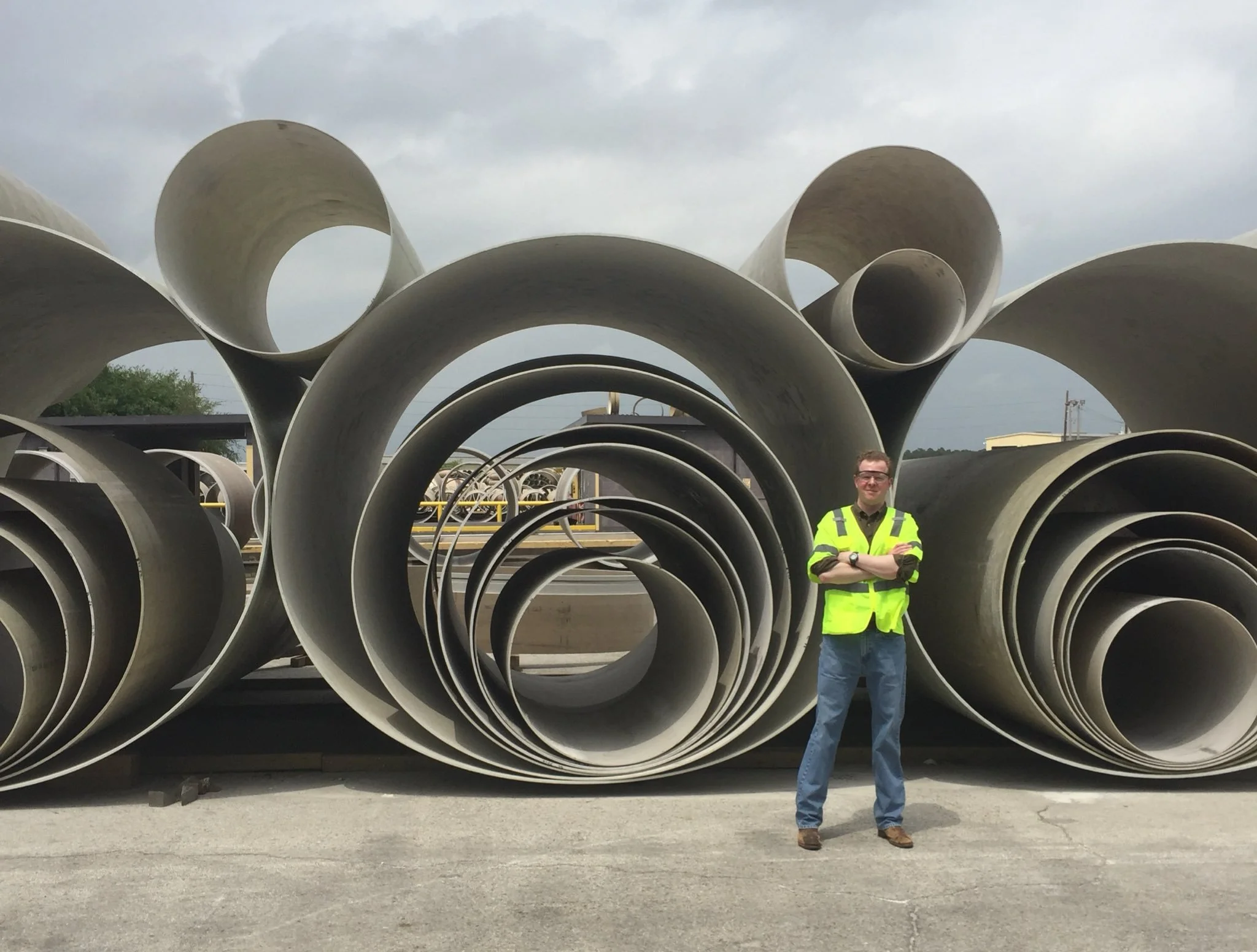 Former Public Utility Commission of Texas Chairman Peter Lake stands next to segments of large water pipes used in major water infrastructure projects.