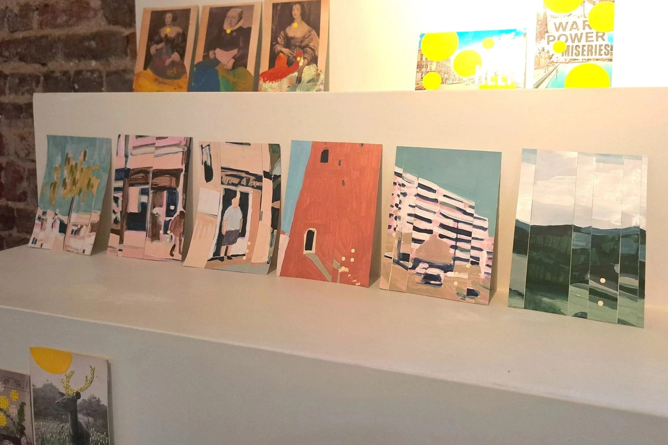 Six collages made from paintings for the call: Restriction by Coupee Collage, displayed on a white wall with a brick wall in the background.