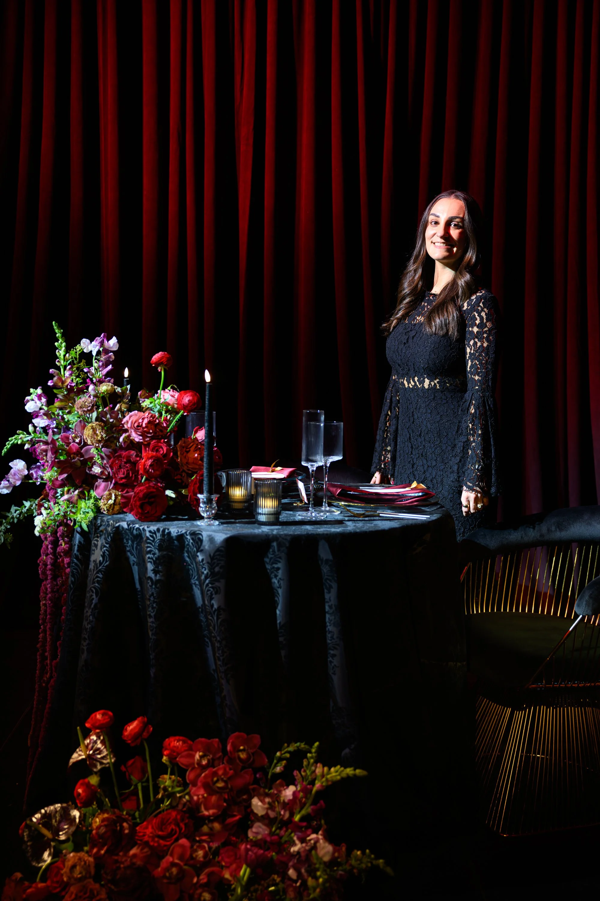 Elegant Wedding Tablescape with Red Floral Arrangement and Dramatic Drapery
