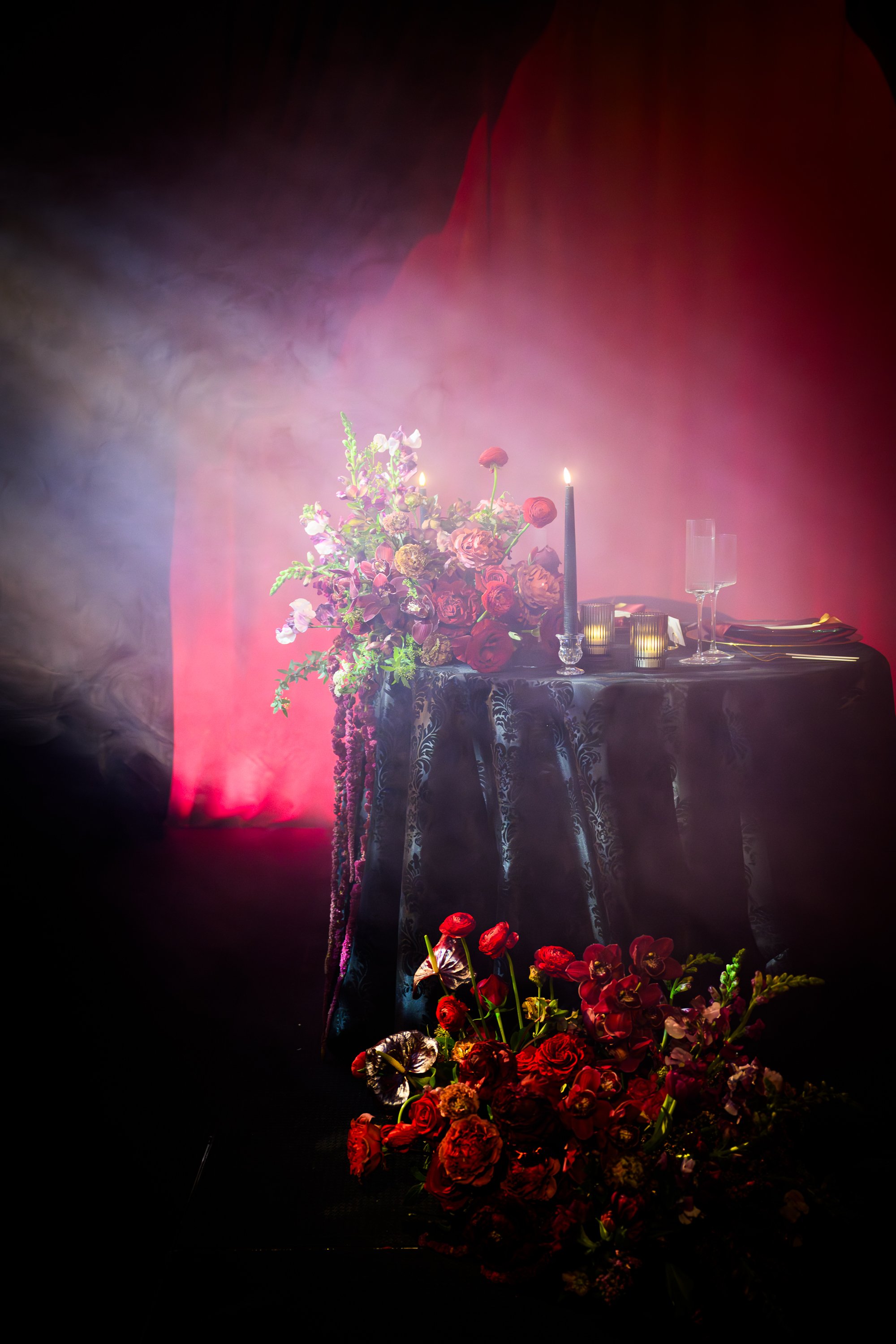 A bride and groom are dancing at their wedding reception under a large tent decorated with string lights and floral arrangements, with guests seated and watching.