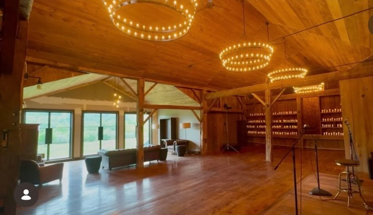 The upper Barn under ring chandeliers, the mountains through the glass doors