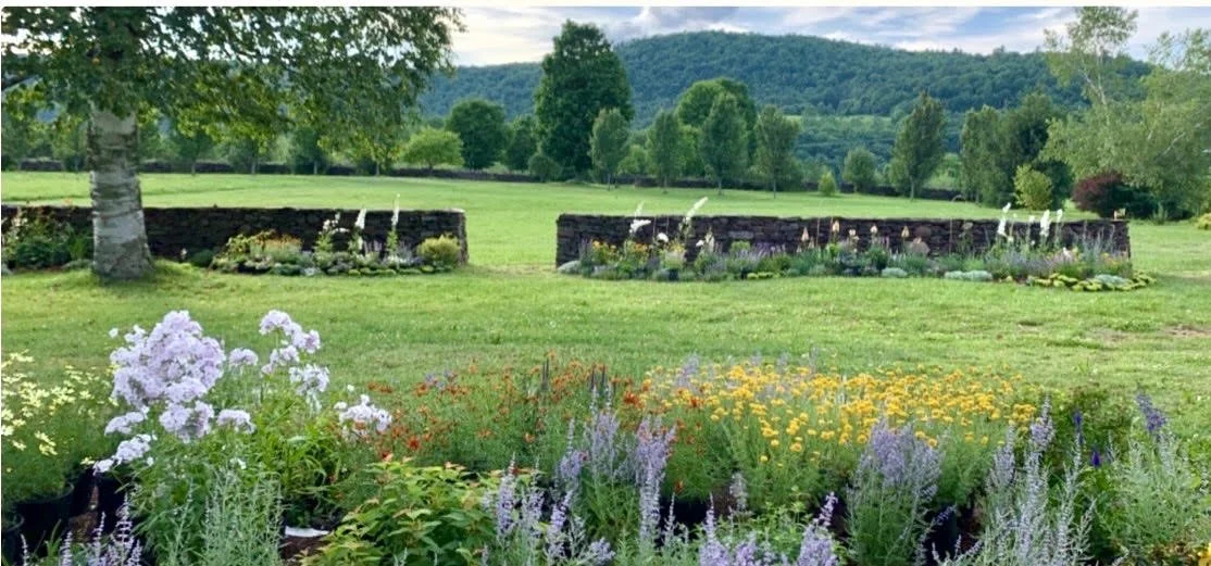 The garden beds in bloom inside the stone walls