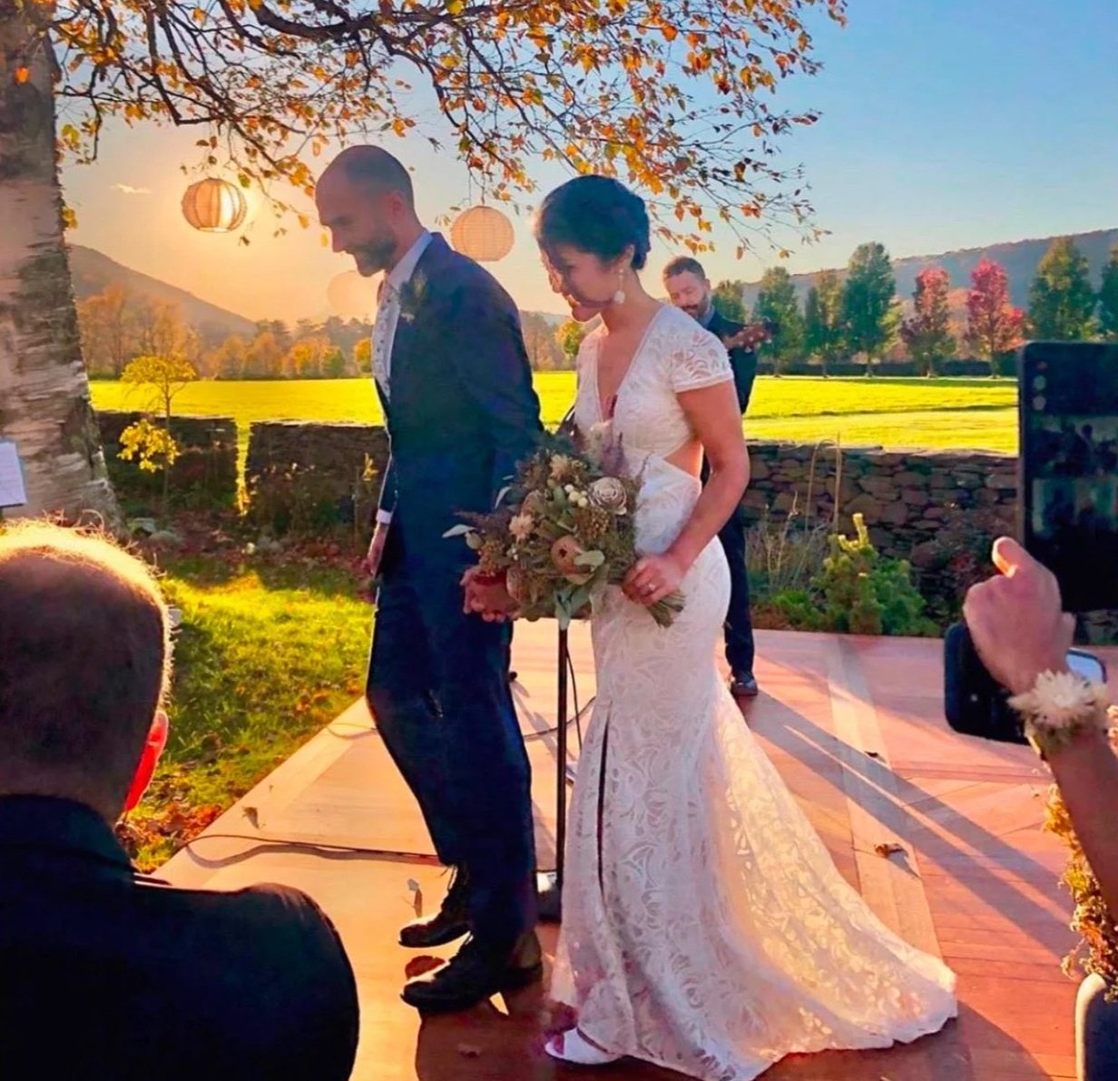 The couple at the ceremony, the field gold behind them