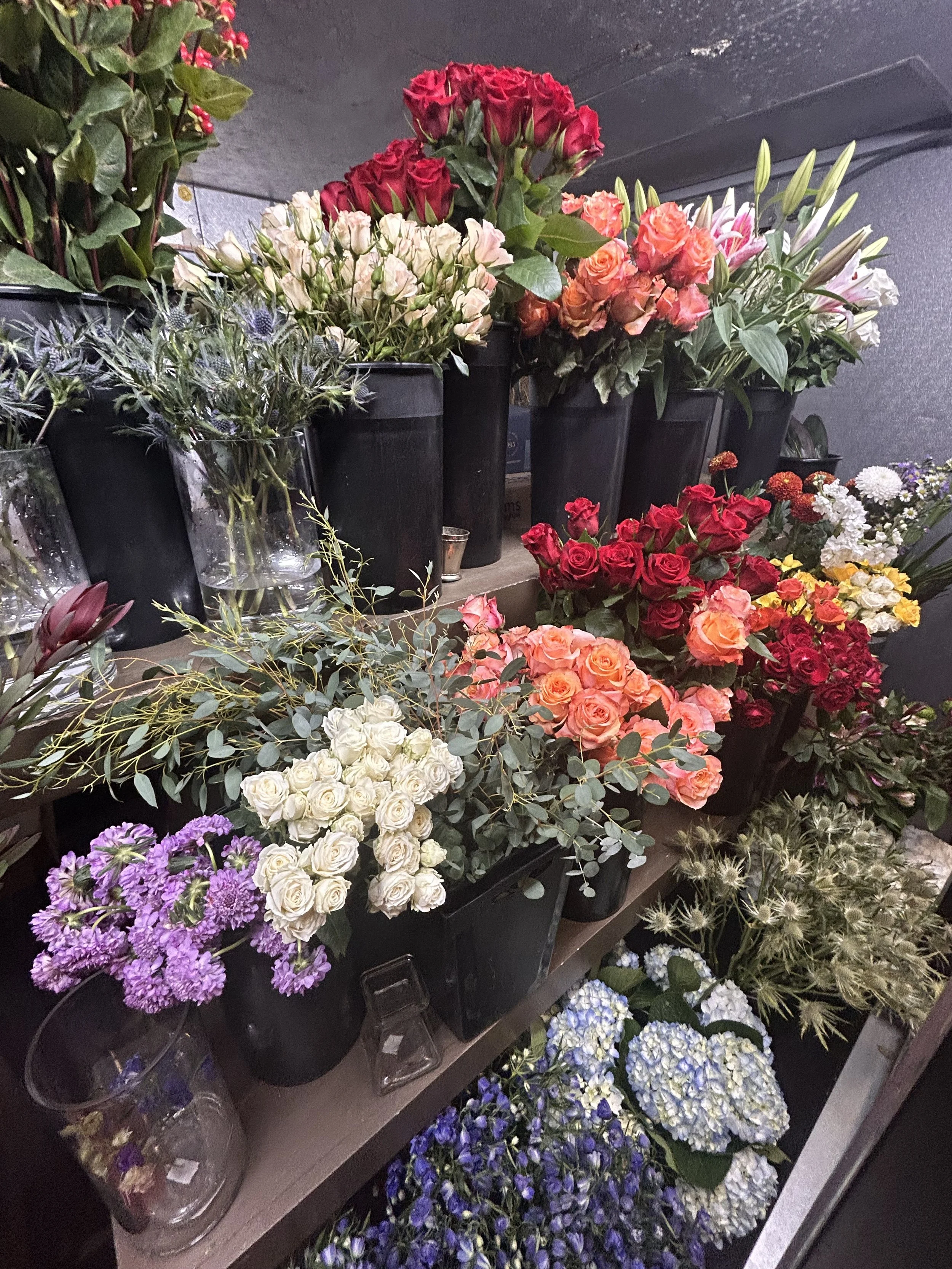 Various colorful flower bouquets and potted plants on display at a flower shop.