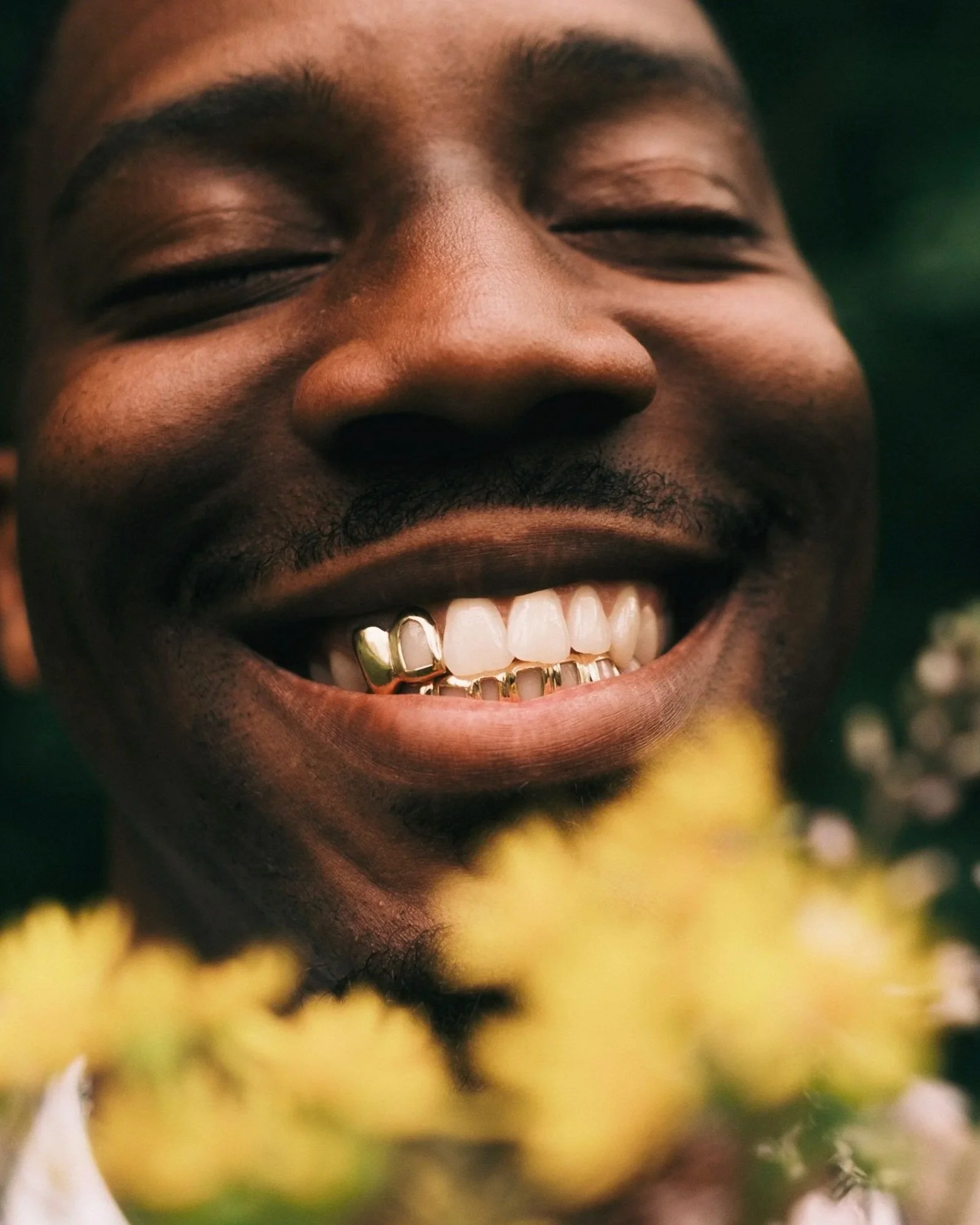 We outside participant smelling flower smiling