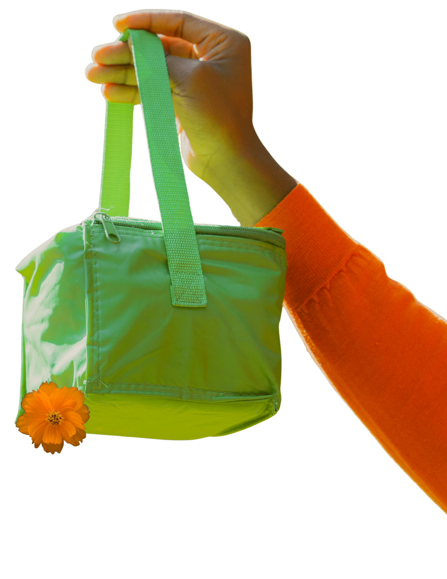 A person wearing an orange long sleeve shirt holding a bright green bag with a strap, with an orange flower placed beside the bag.