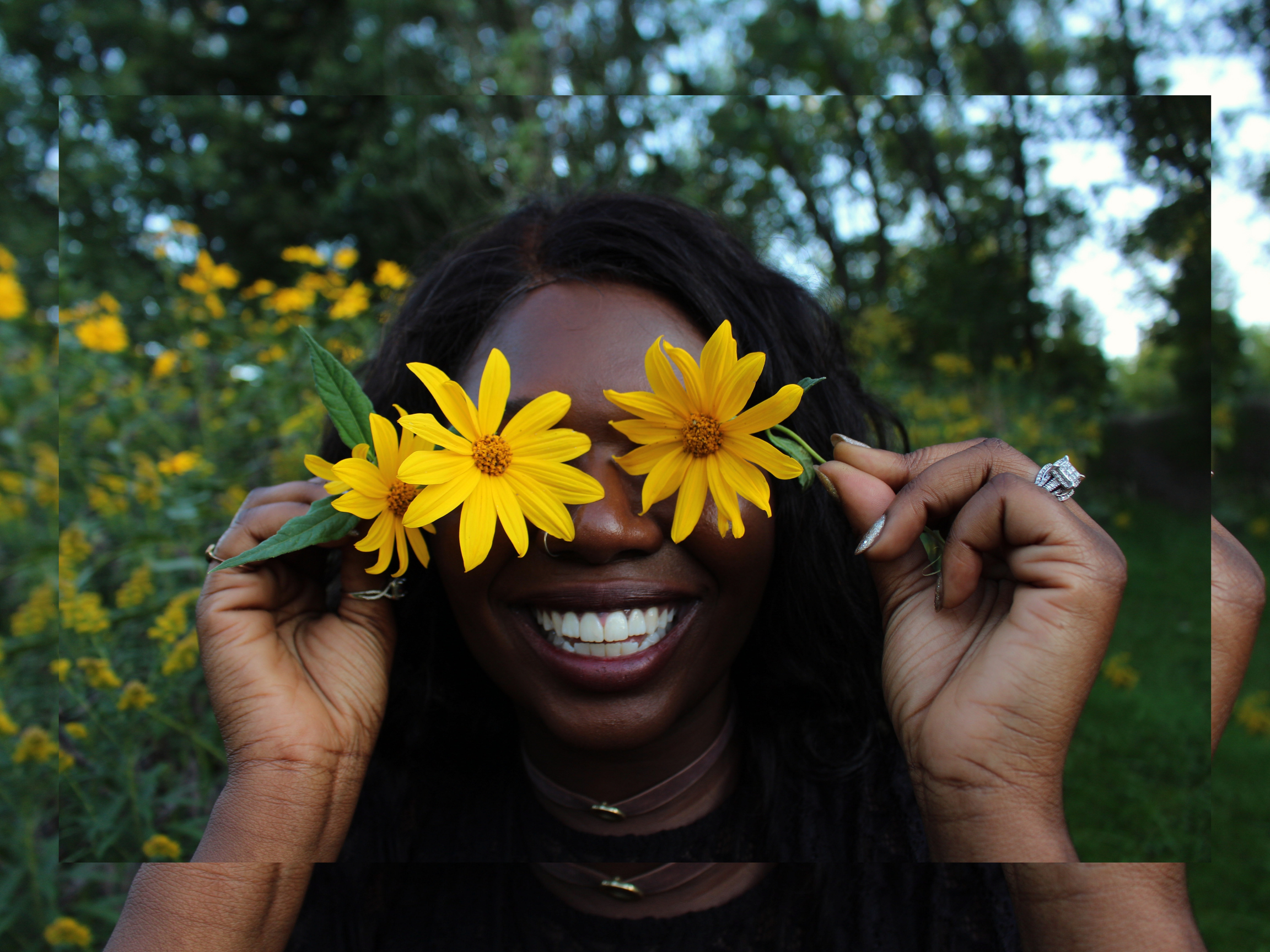 smiling woman with flowers over eyes