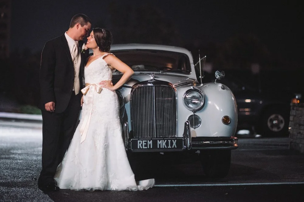 Newly weds in front of their getaway car