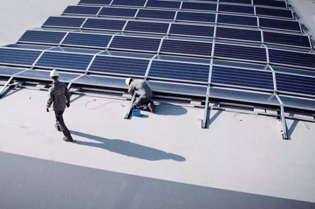Workers installing solar panels on a rooftop