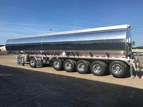 Shiny stainless steel tanker trailer parked on a sunny day