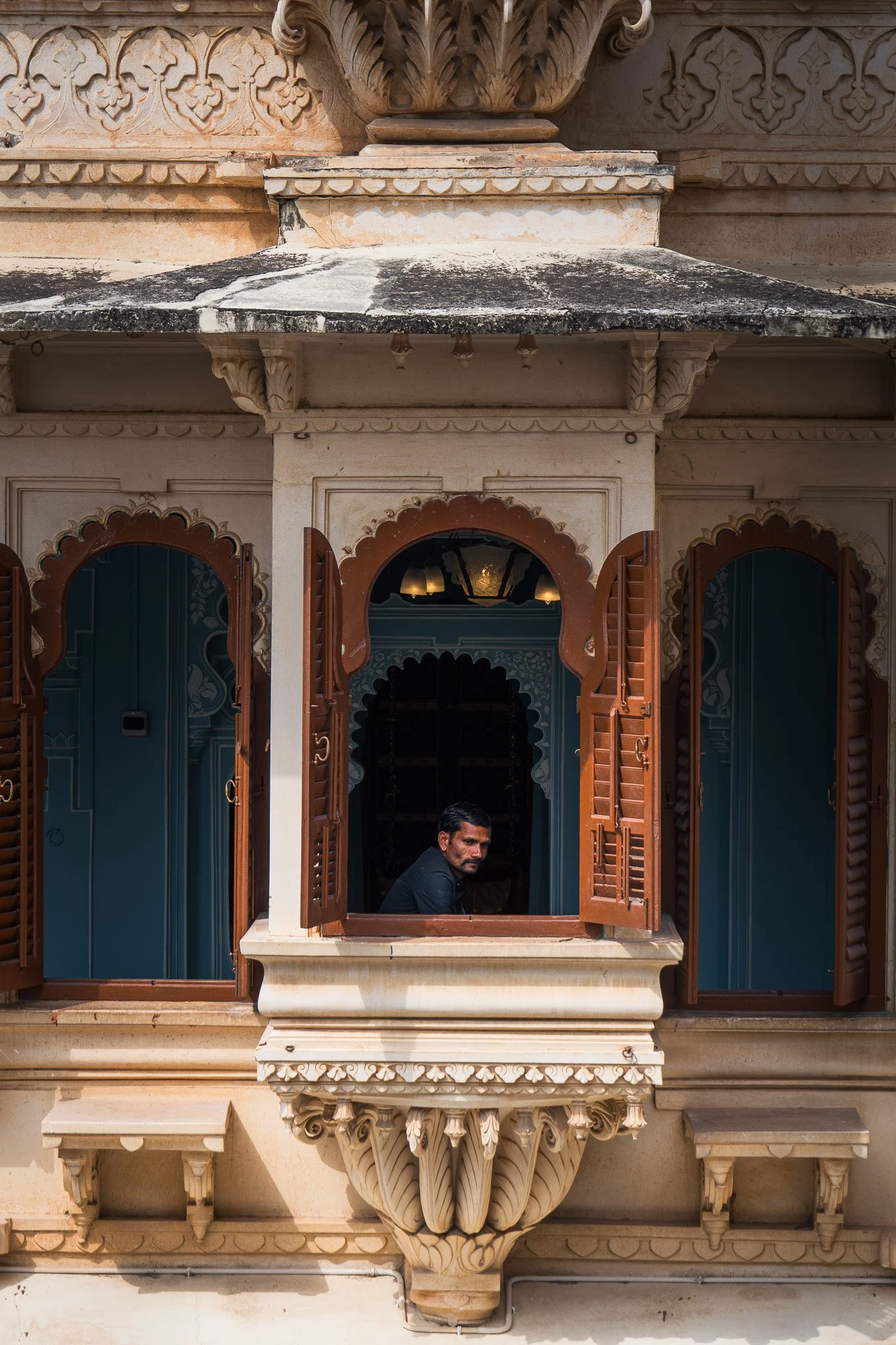 Udaipur-City-Palace-Mann-schaut-aus-Fenster.jpg