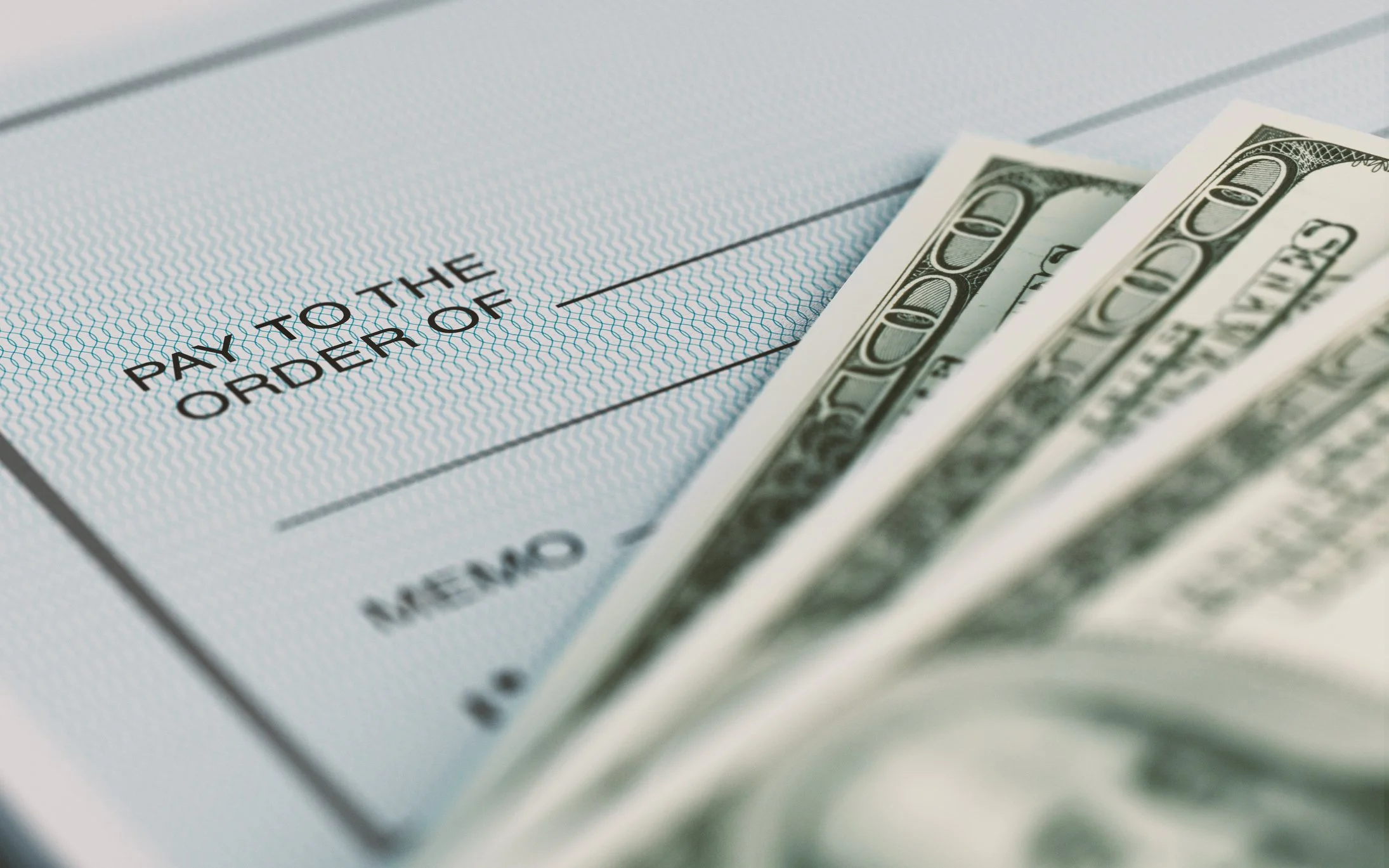 Close-up picture of a personal check and American Dollars.
