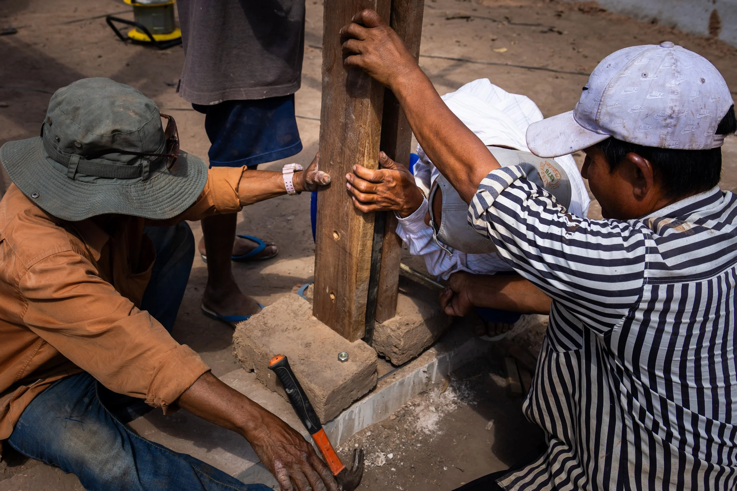 a group of children sit in a circle on a concrete floor
