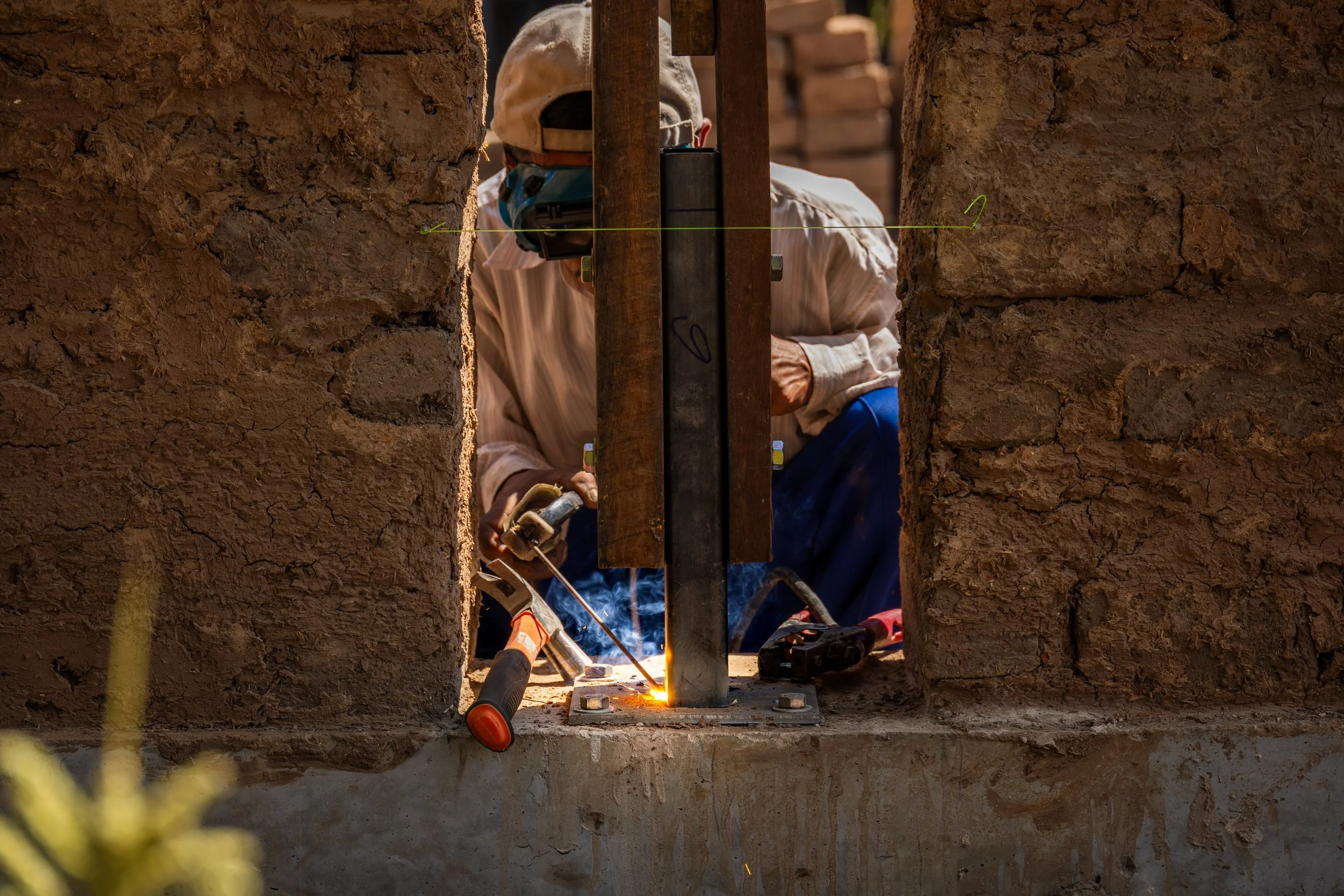an architect presents drawings to a group of builders in a classroom setting