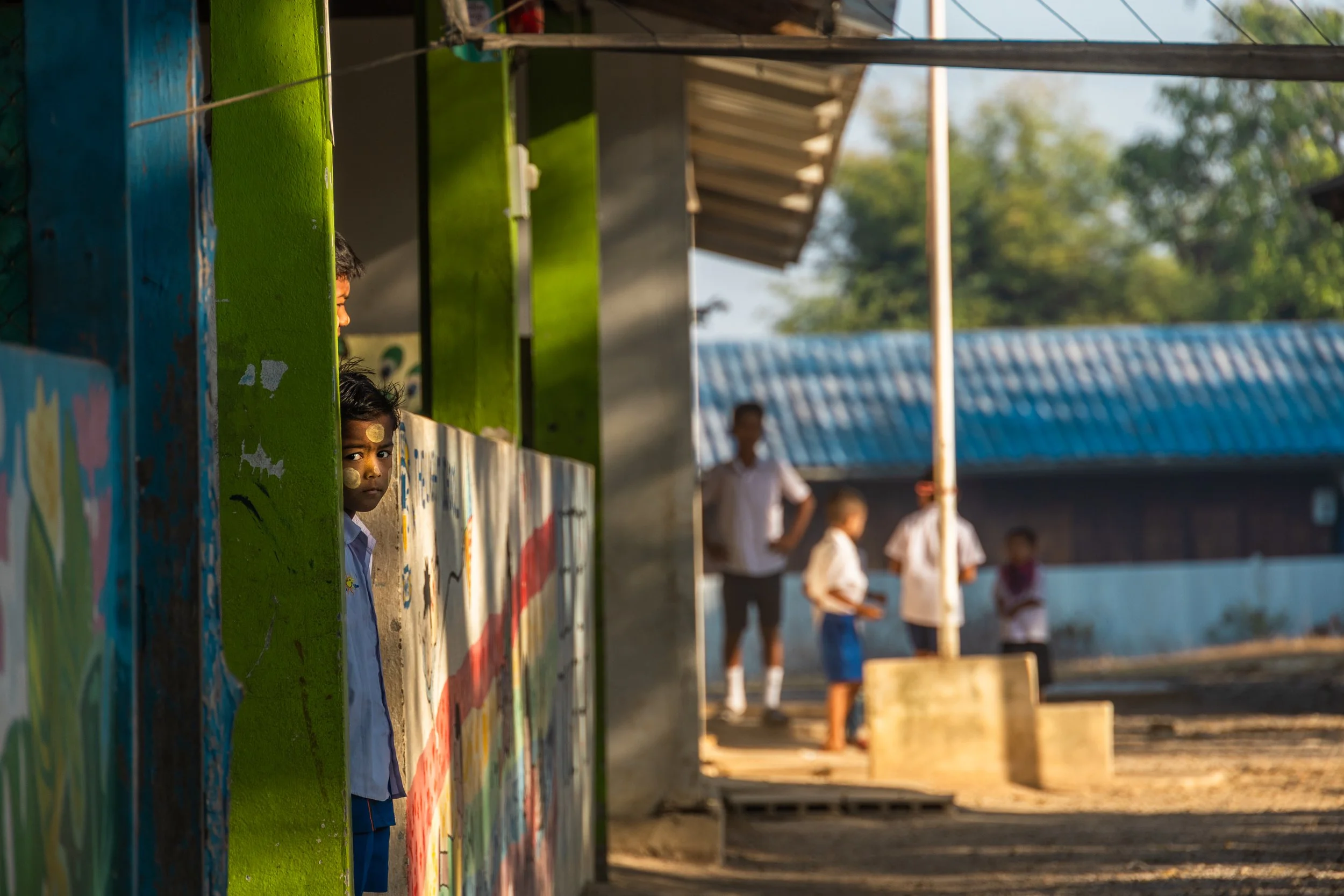 students and teacher inside a bamboo classroom 