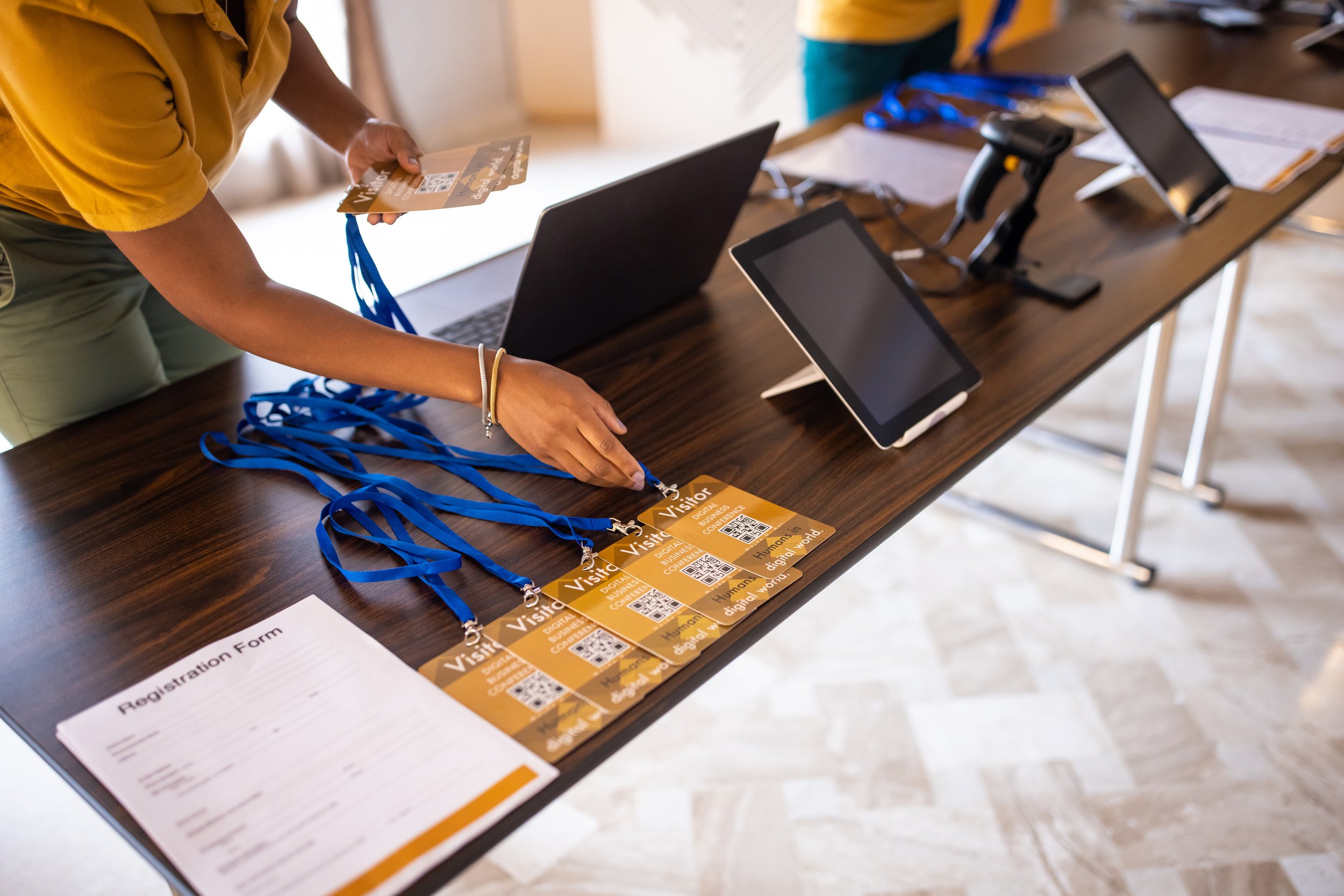 Table at business event featuring registration forms and badges