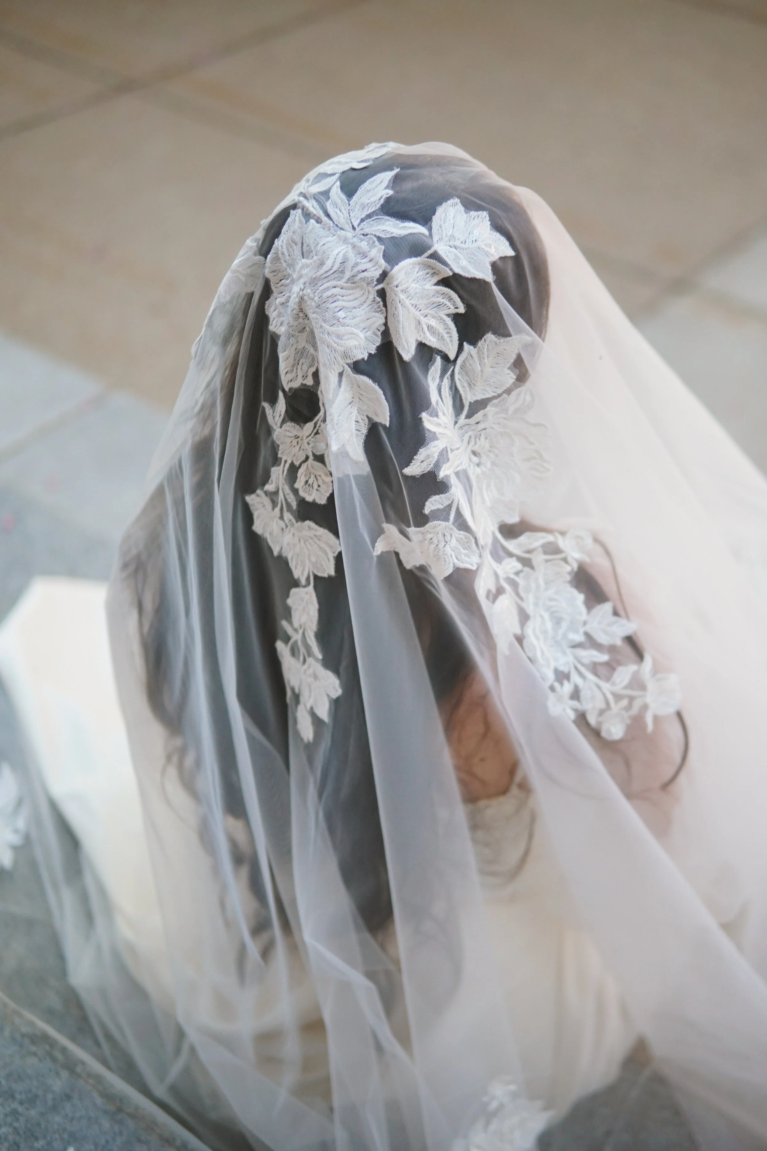 Close picture of the floral lace veil on  the entire head area with mix of large and small flowers and branches