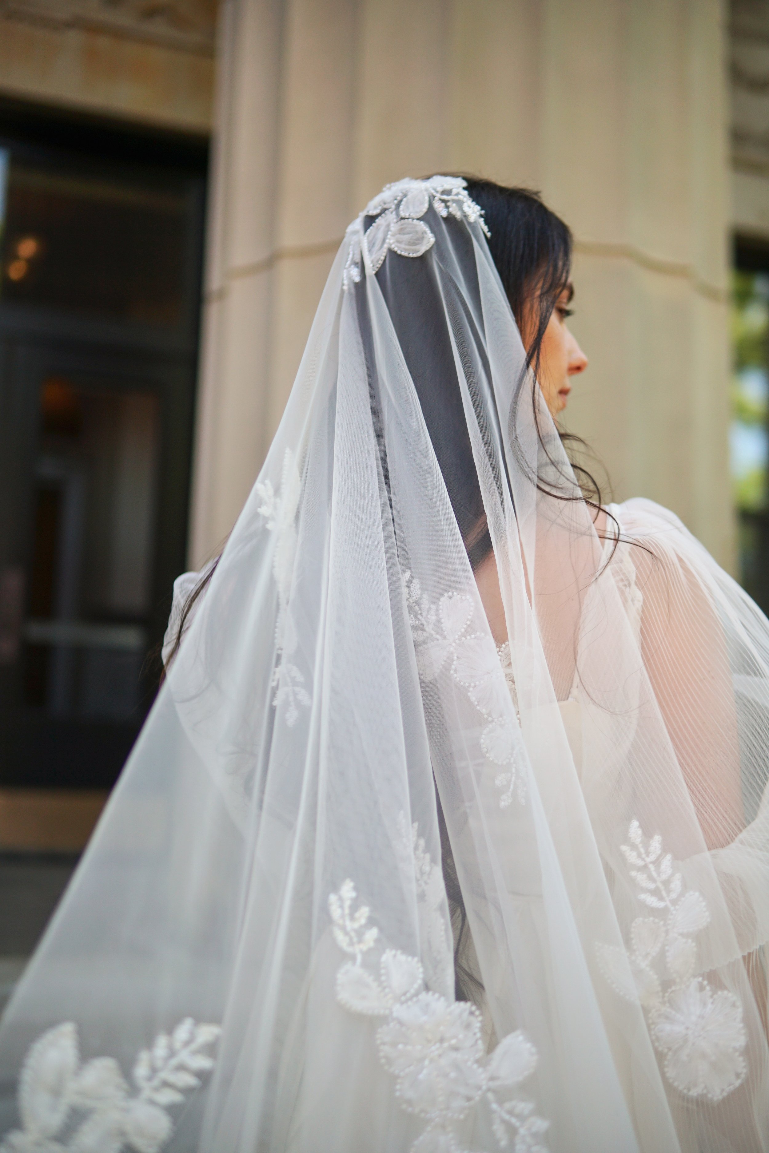 The picture of a floral veil crafted from soft, sheer tulle. It features floral beaded lace appliqués gracefully scattered throughout the entire veil, creating a romantic and ethereal look.