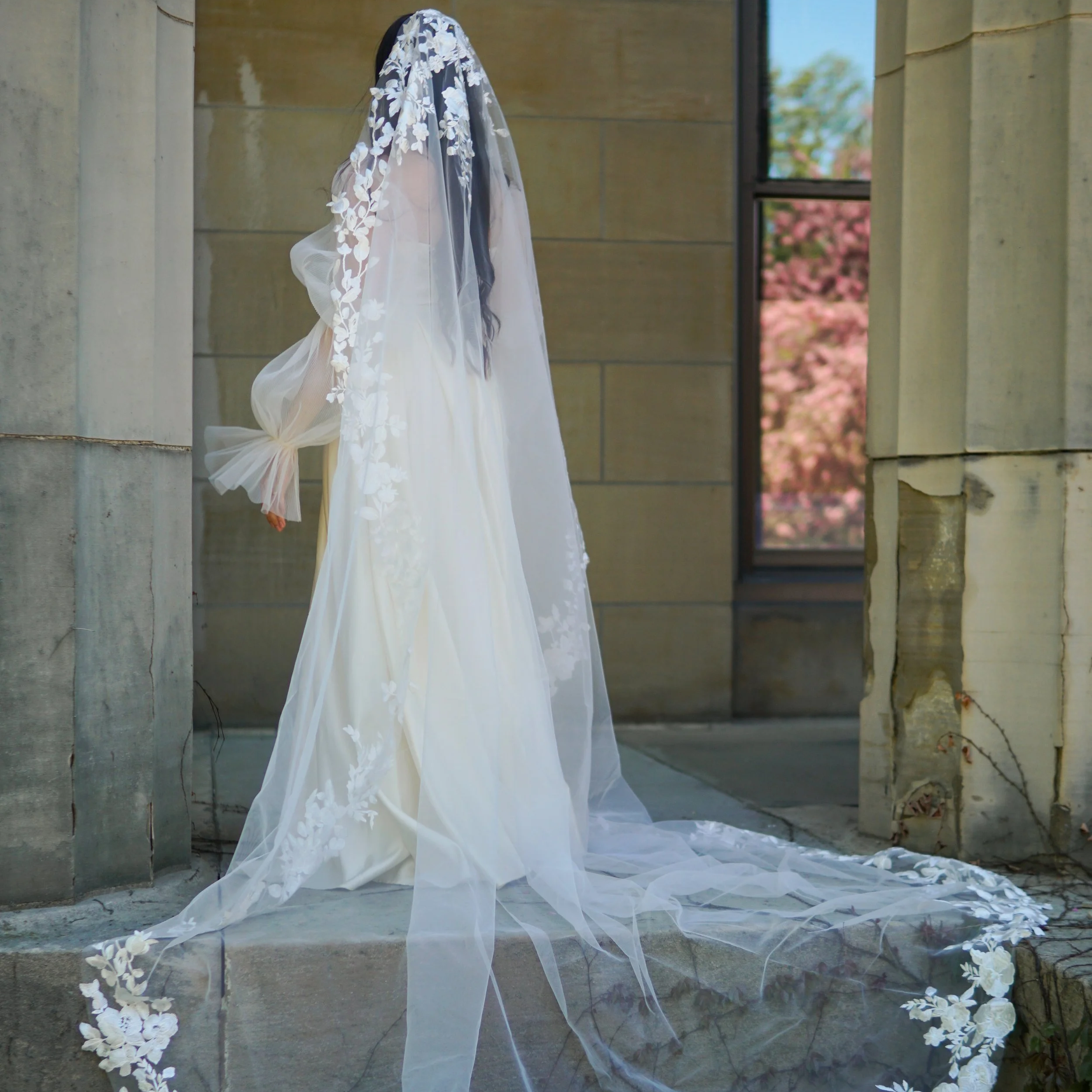 Bride wearing a full lace mantilla floral lace veil with mix of small and bigger flowers