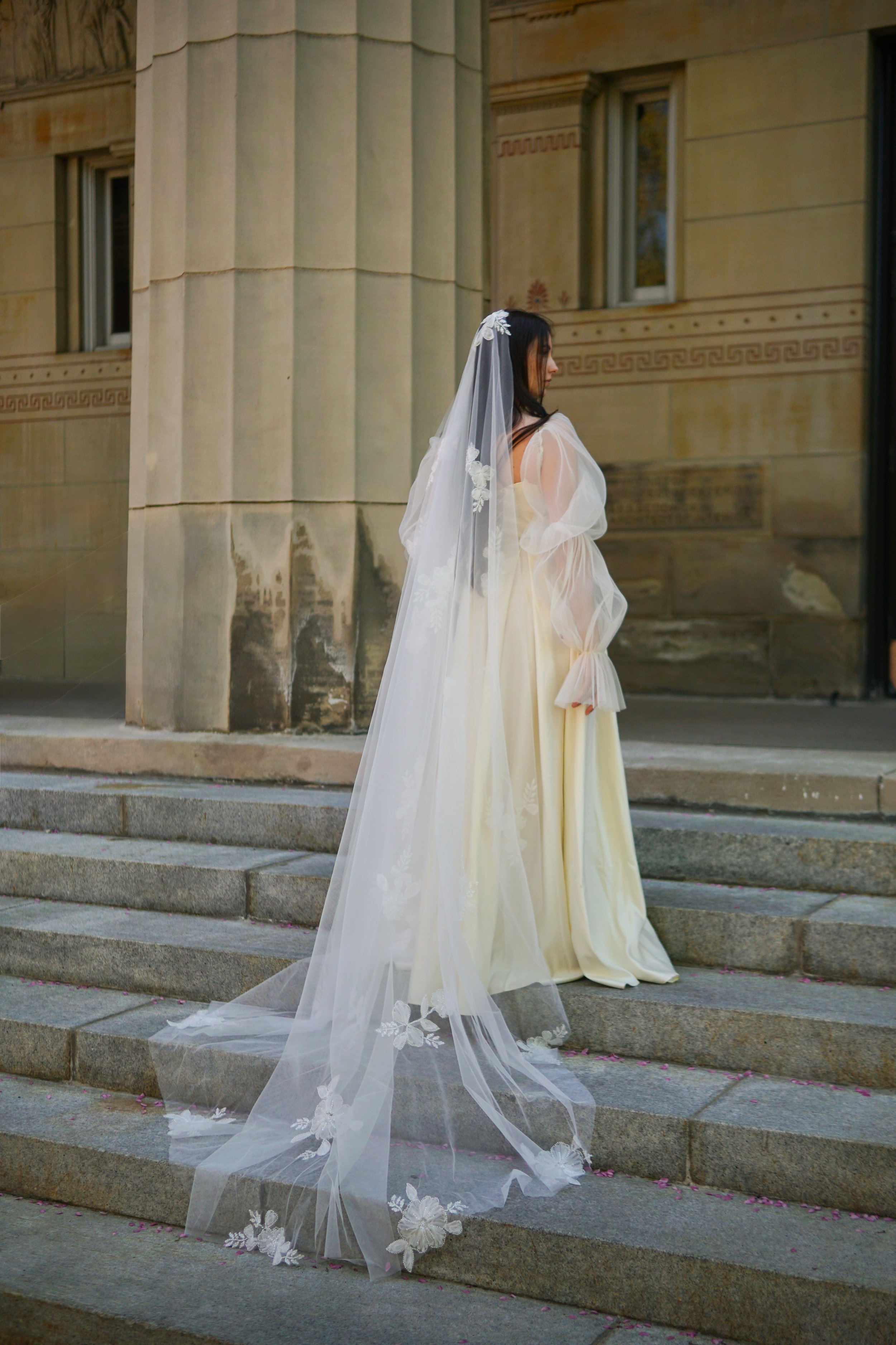 The picture of a floral veil crafted from soft, sheer tulle. It features floral beaded lace appliqués gracefully scattered throughout the entire veil.