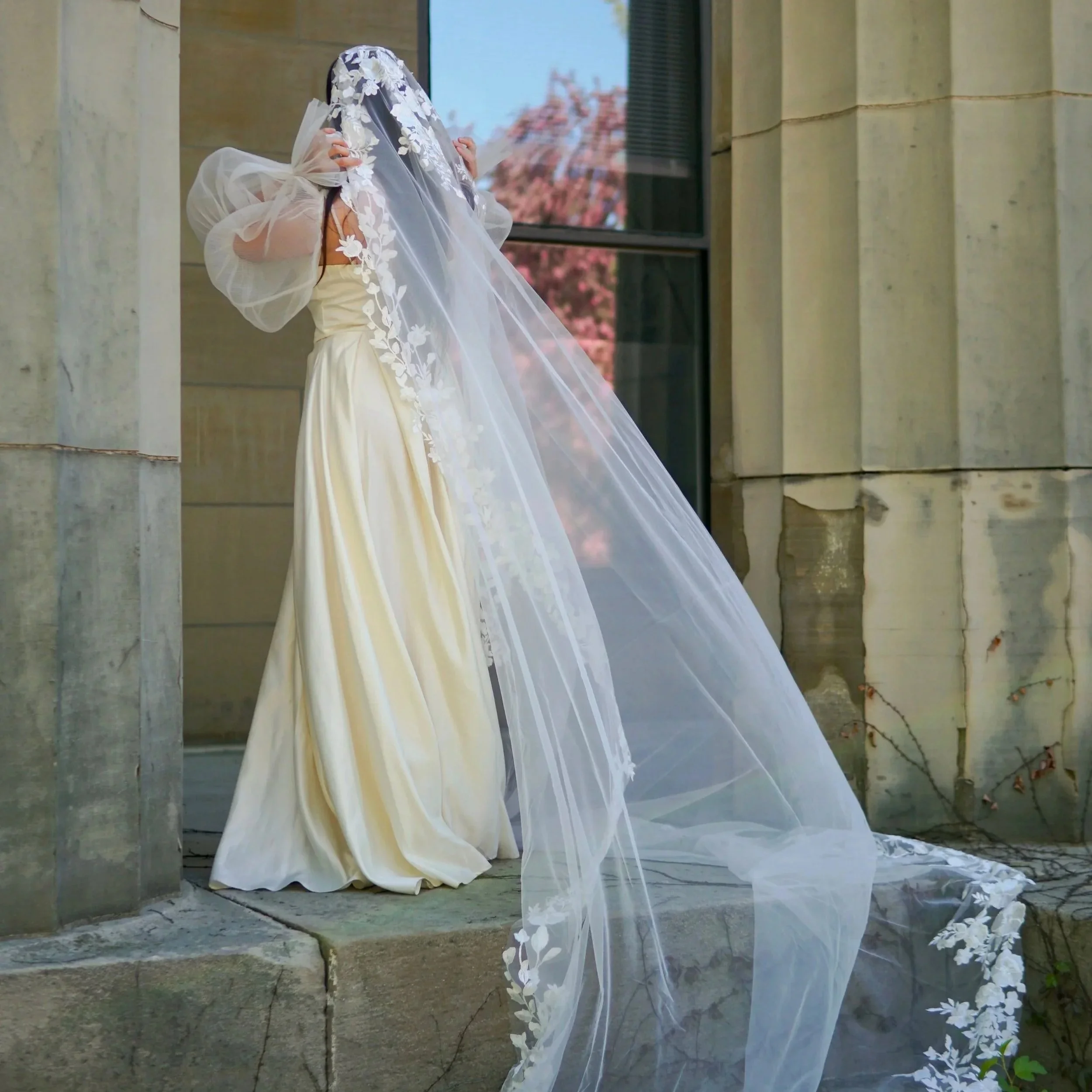 Bride wearing a full lace mantilla floral lace veil with mix of small and bigger flowers