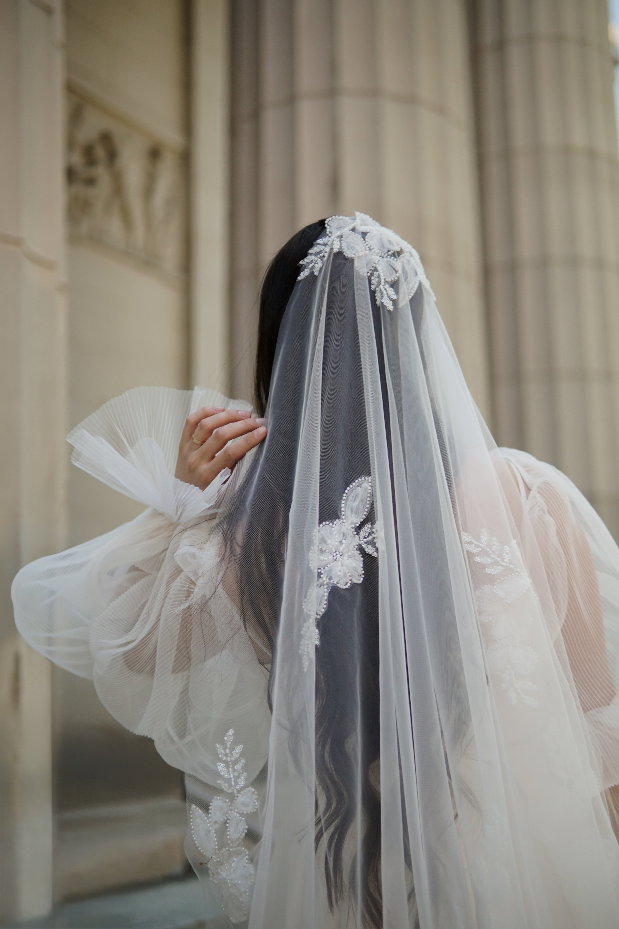 The picture of a floral veil crafted from soft, sheer tulle. It features floral beaded lace appliqués gracefully scattered throughout the entire veil, creating a romantic and ethereal look.