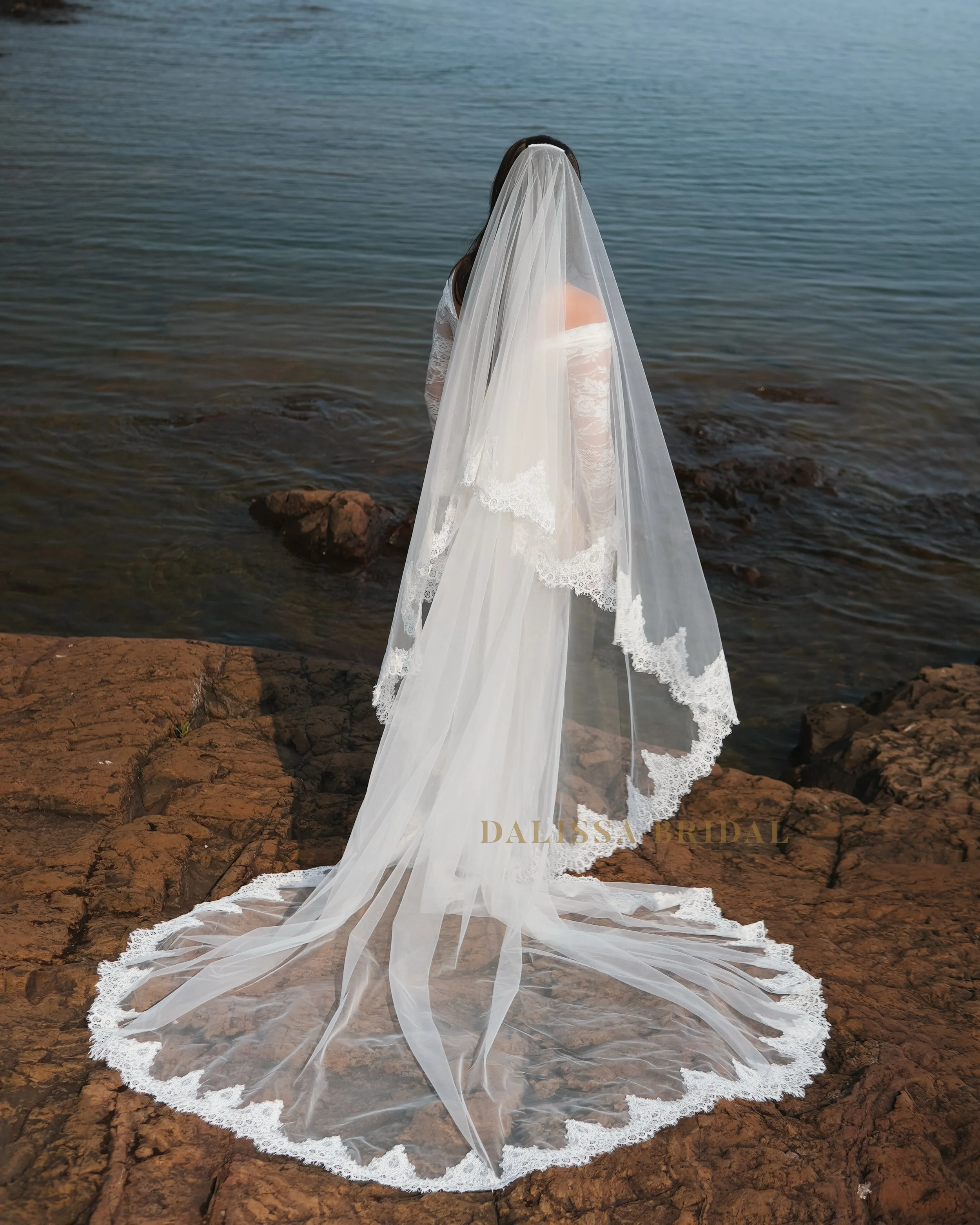 picture from the back of the bride wearing two-tier lace trim veil.