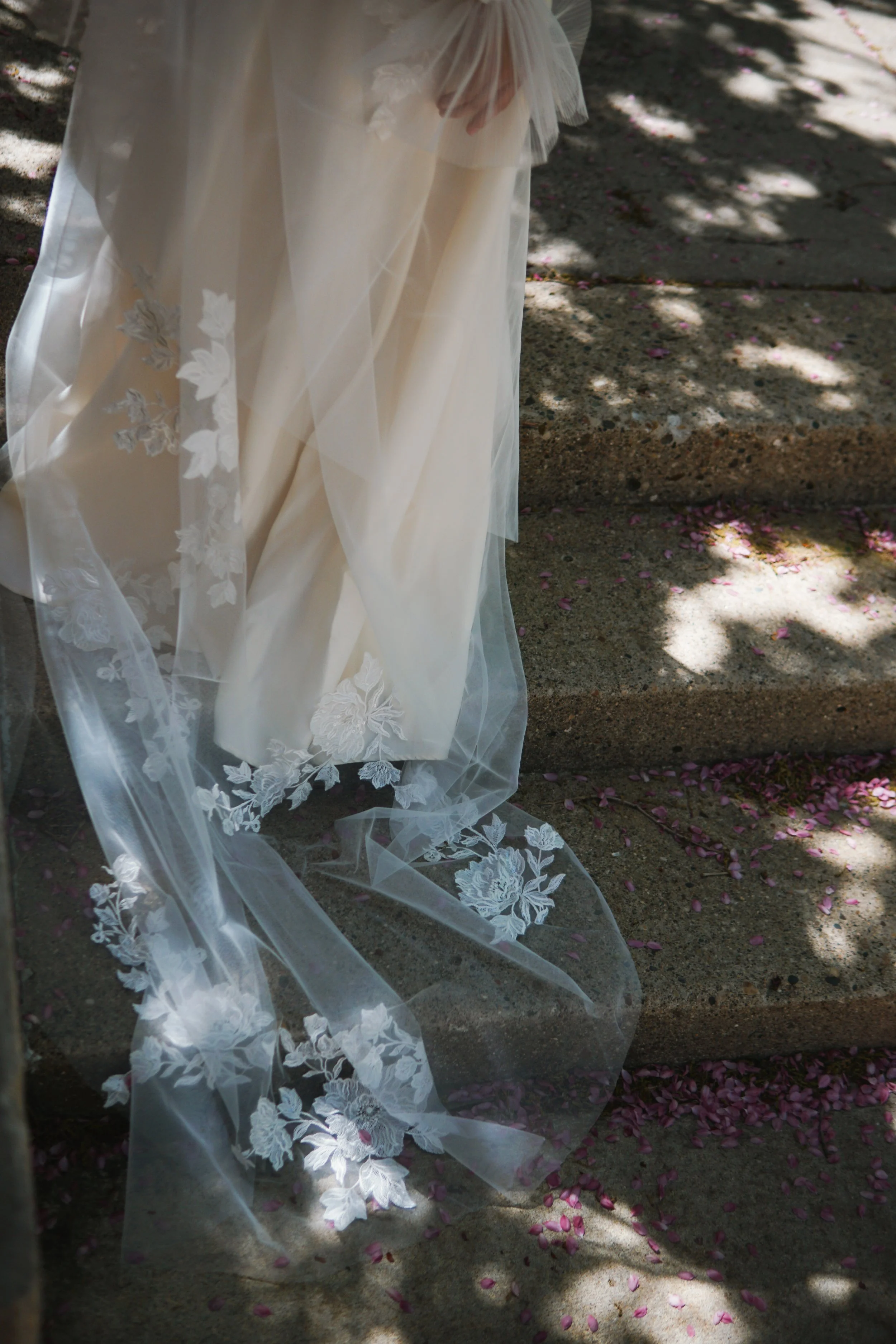 The photo shows part of the veil laid on a stone floor, highlighting the large floral lace appliqués in detail.
